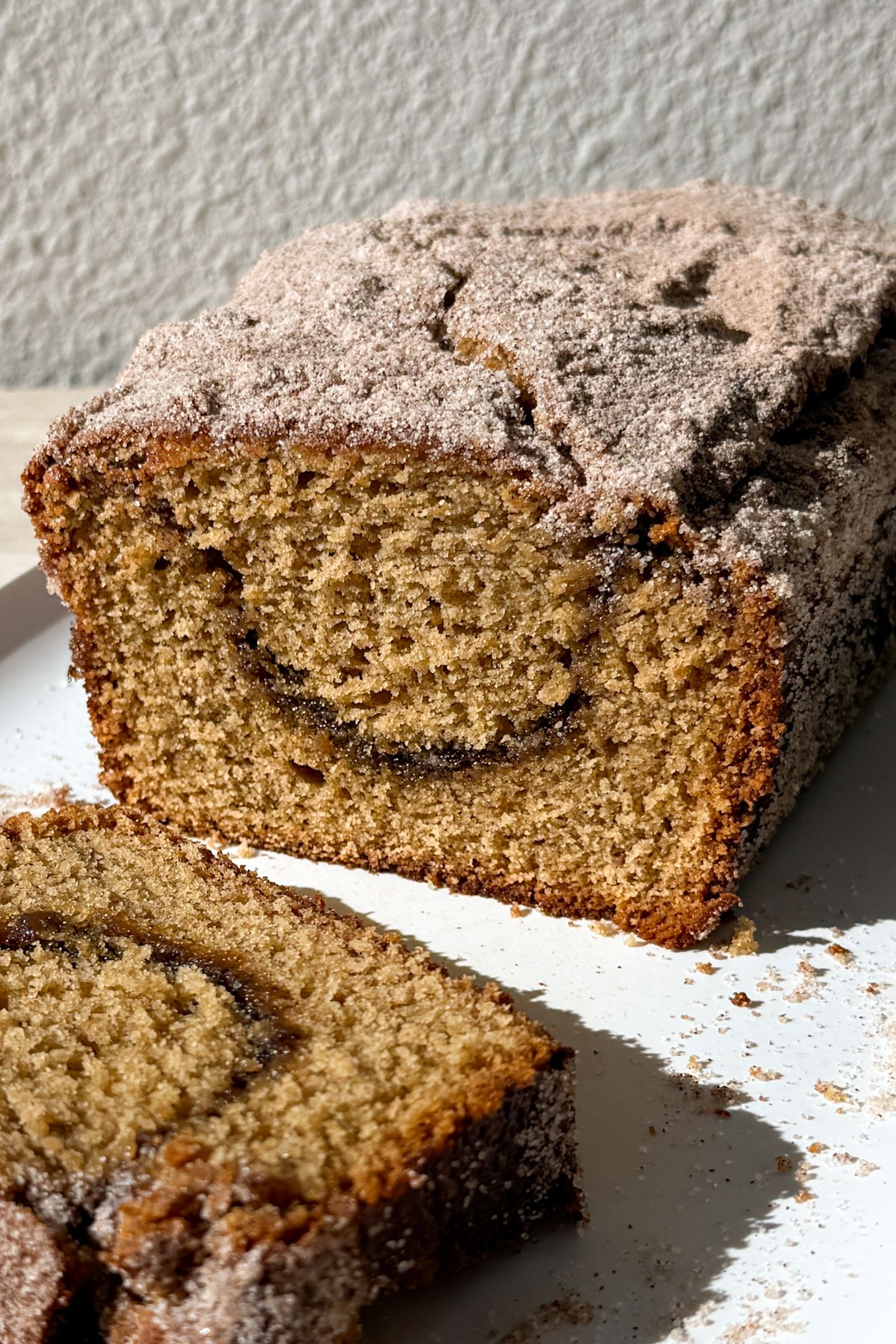 Slicing the apple cider bread on a platter.