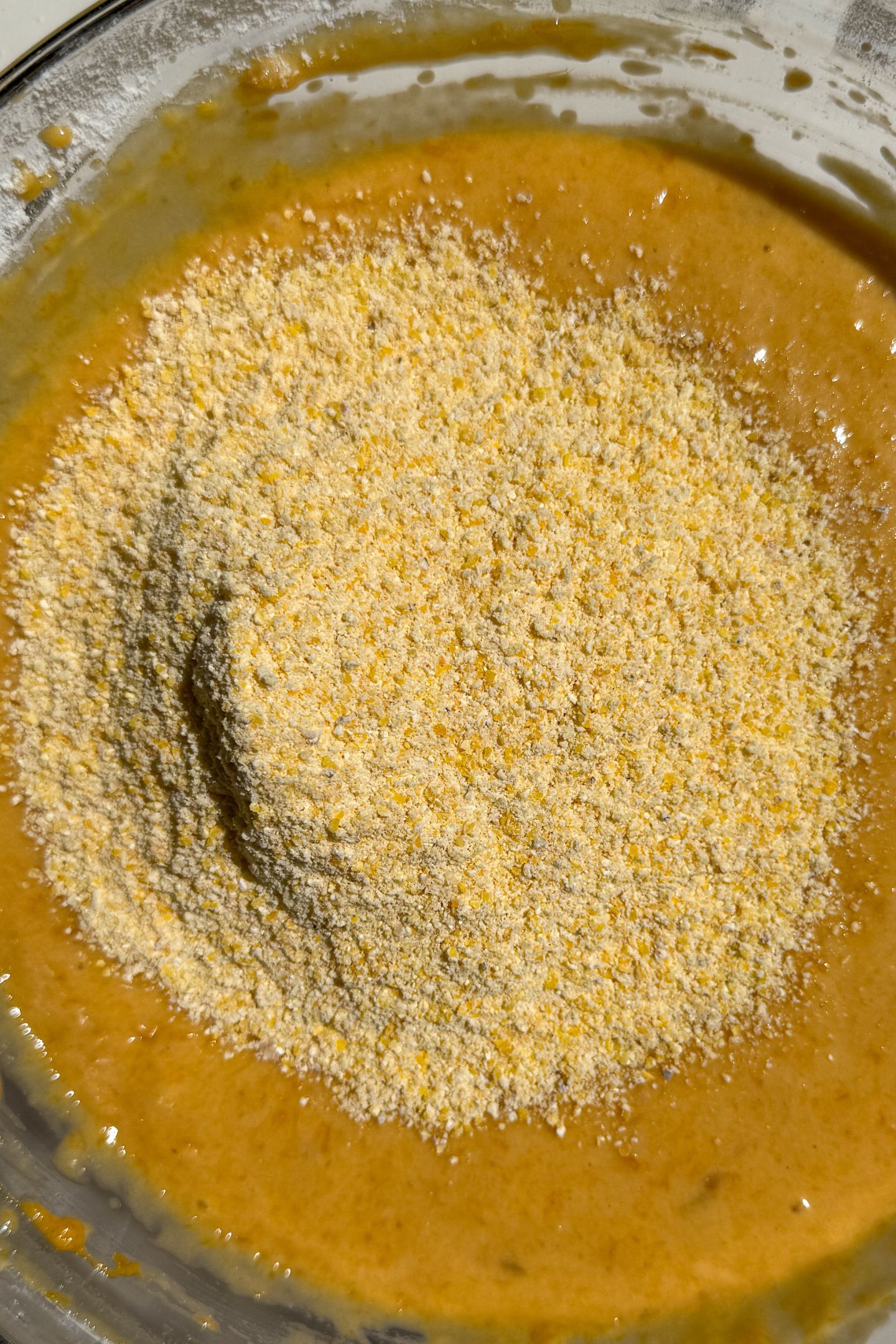Adding cornmeal to the batter.