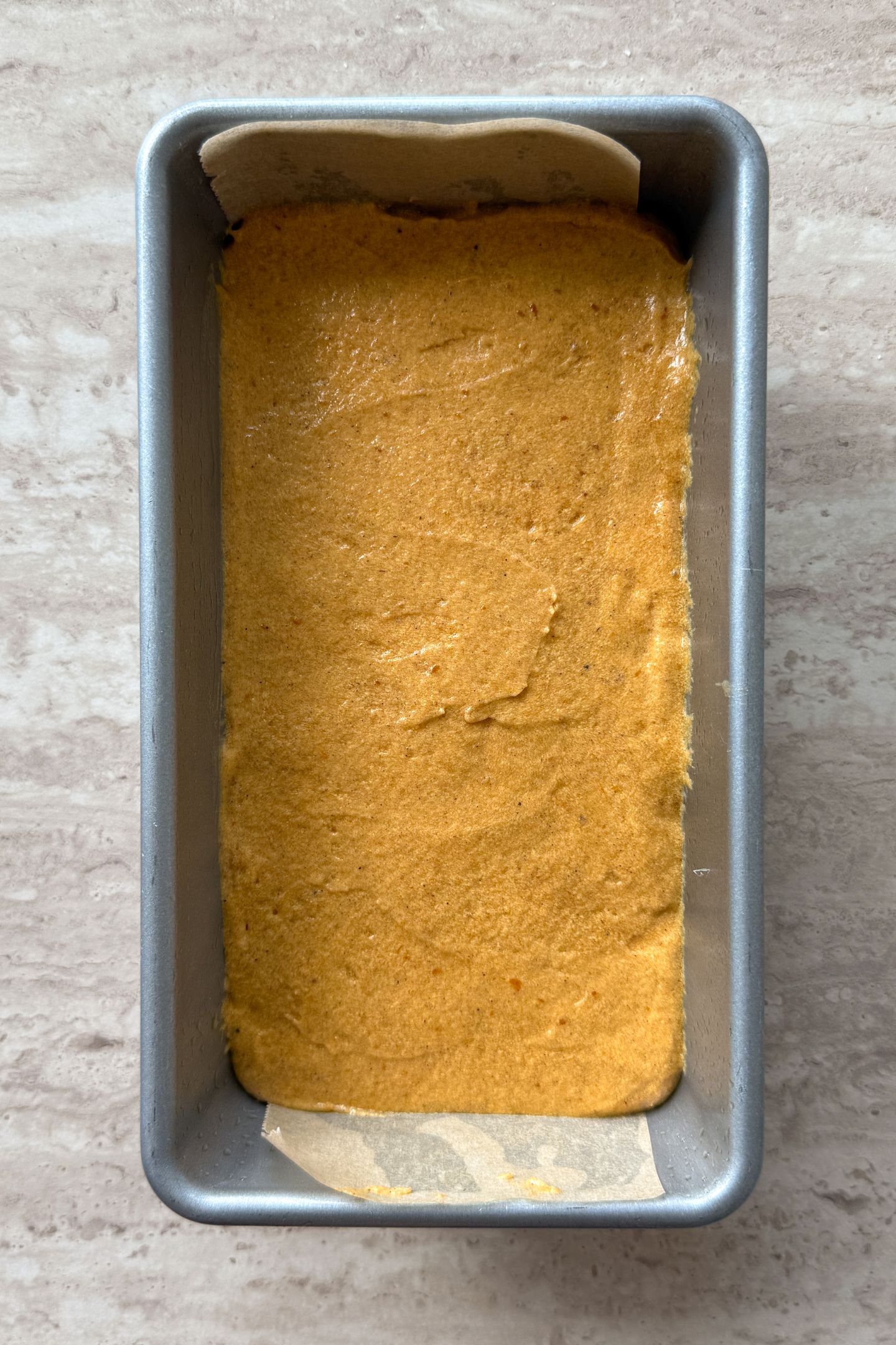 The pumpkin bread batter transferred to the loaf pan.