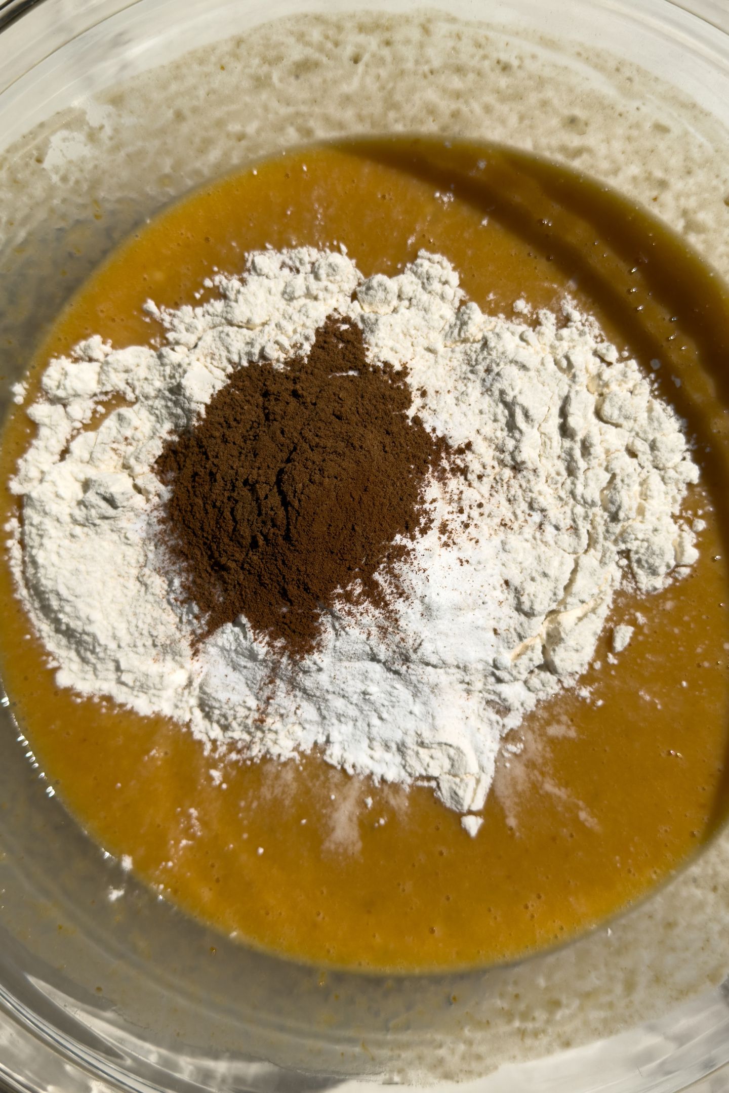 Wet ingredients mixed in a bowl, topped with the dry ingredients.