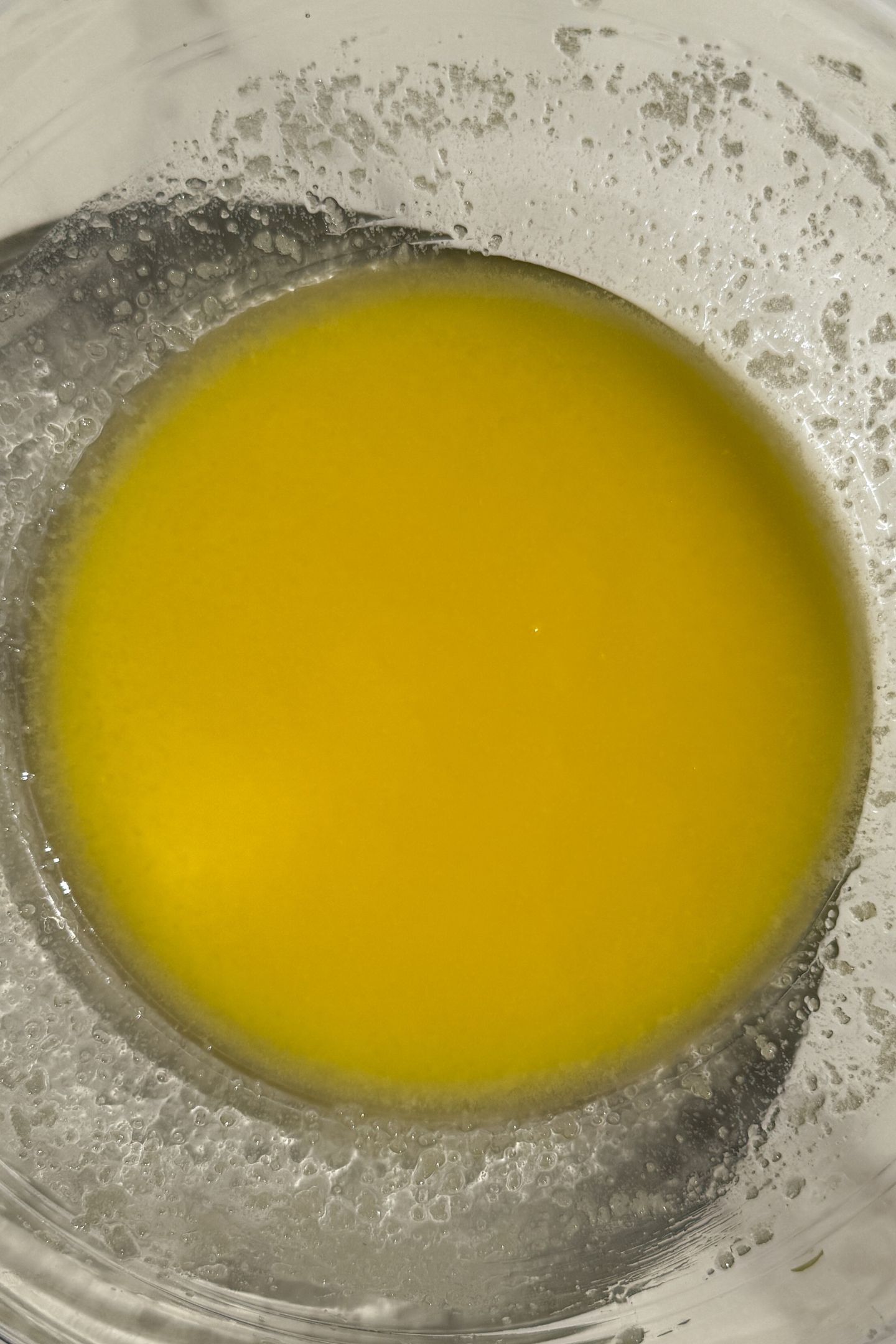 Melted butter in a bowl mixed with granulated sugar.