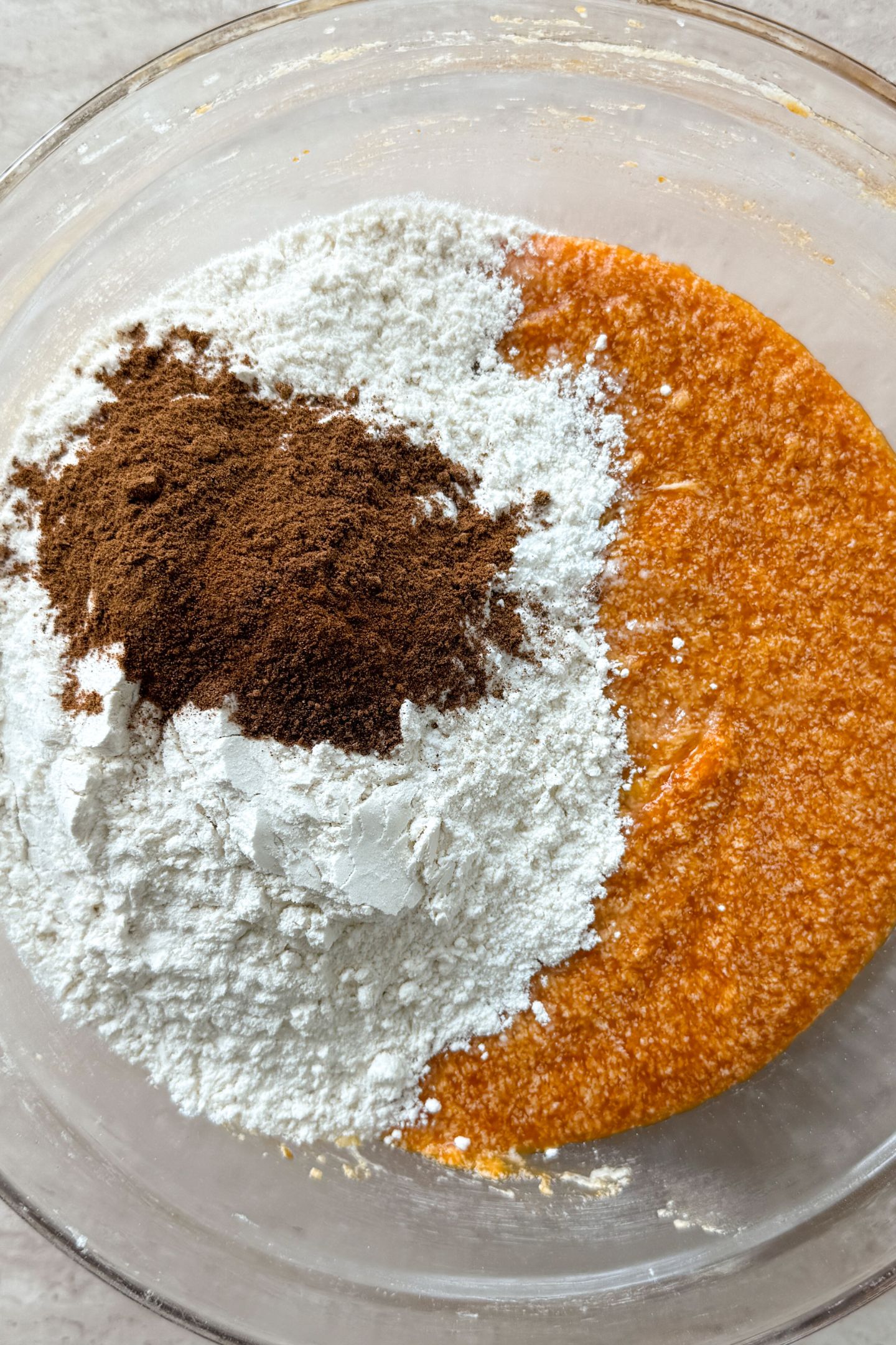 Adding the dry ingredients to the wet in the mixing bowl.