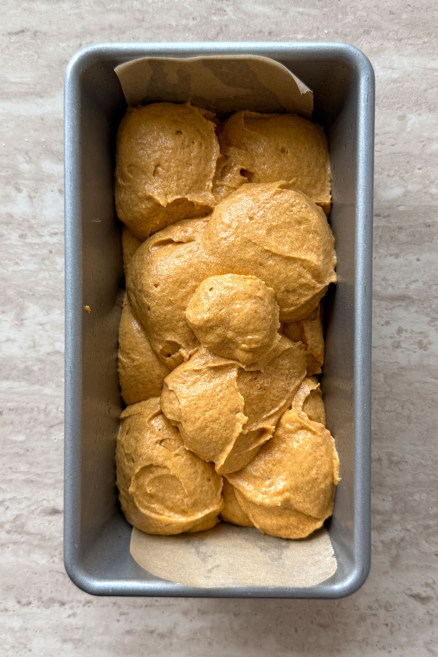 The pumpkin bread batter transferred to the loaf pan.