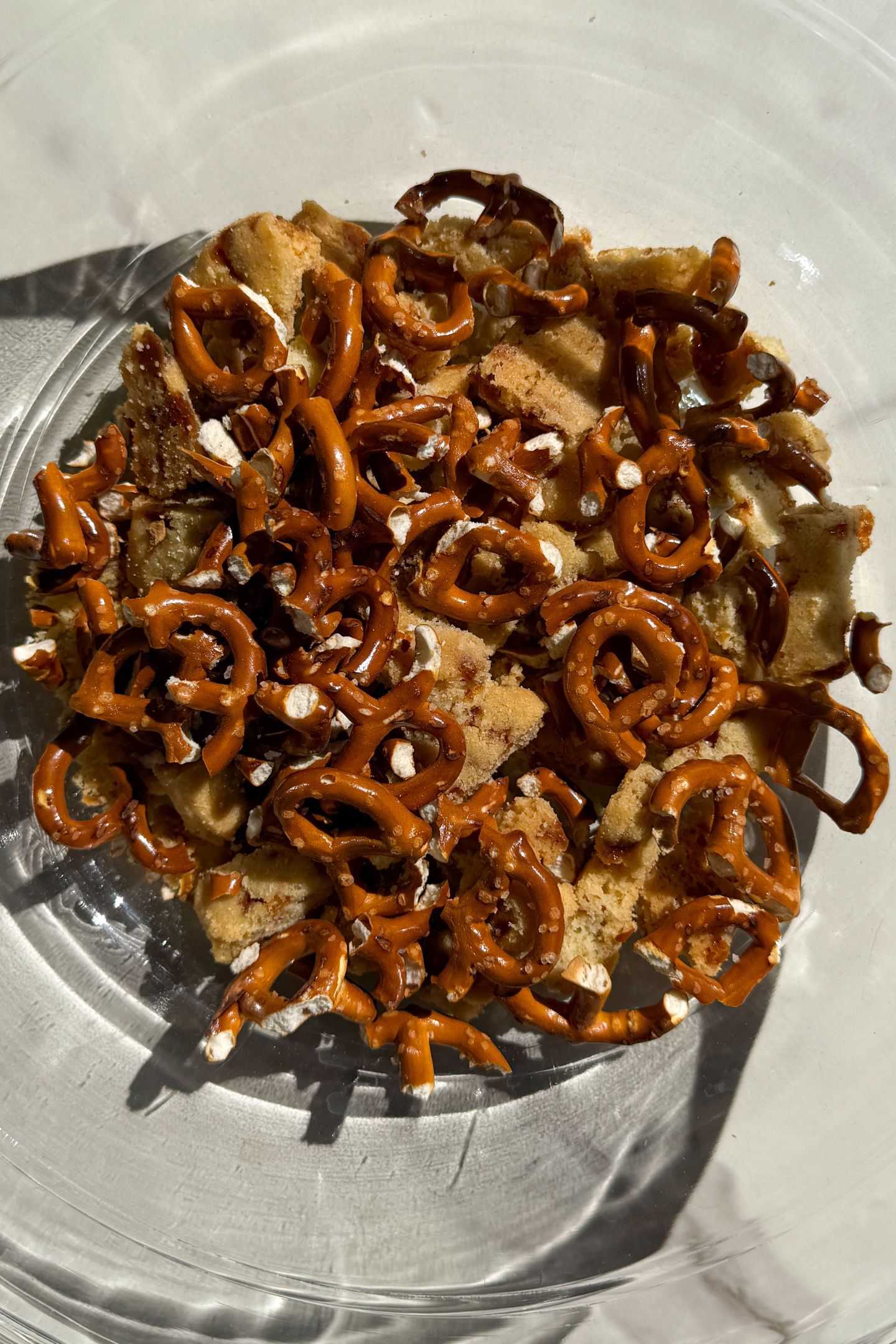 Broken pretzel pieces and shortbread in a bowl.
