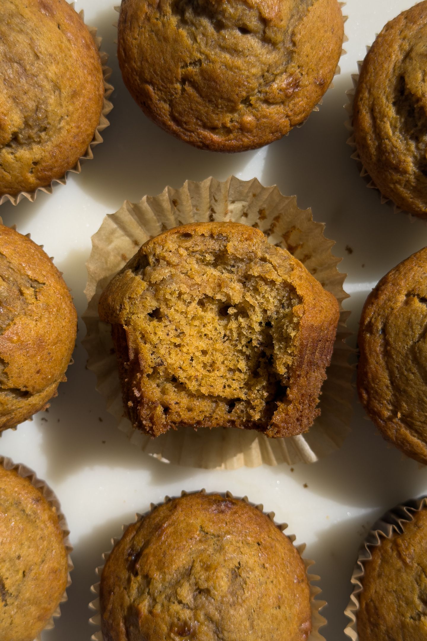 Pumpkin and banana bread muffin with a bite taken out of it.