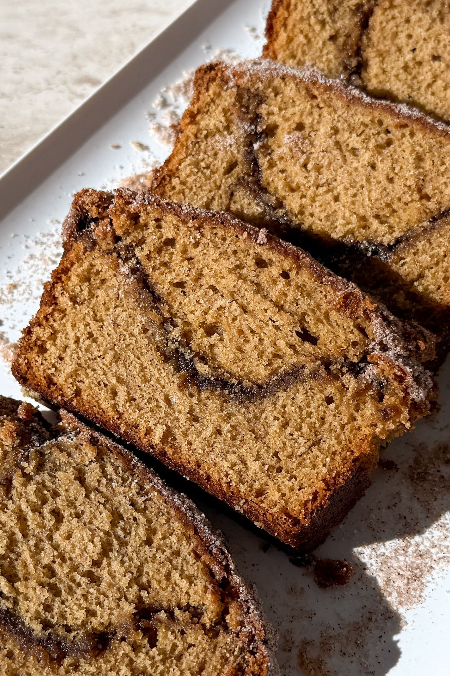 Slices of apple cider bread layered on each other on a platter.