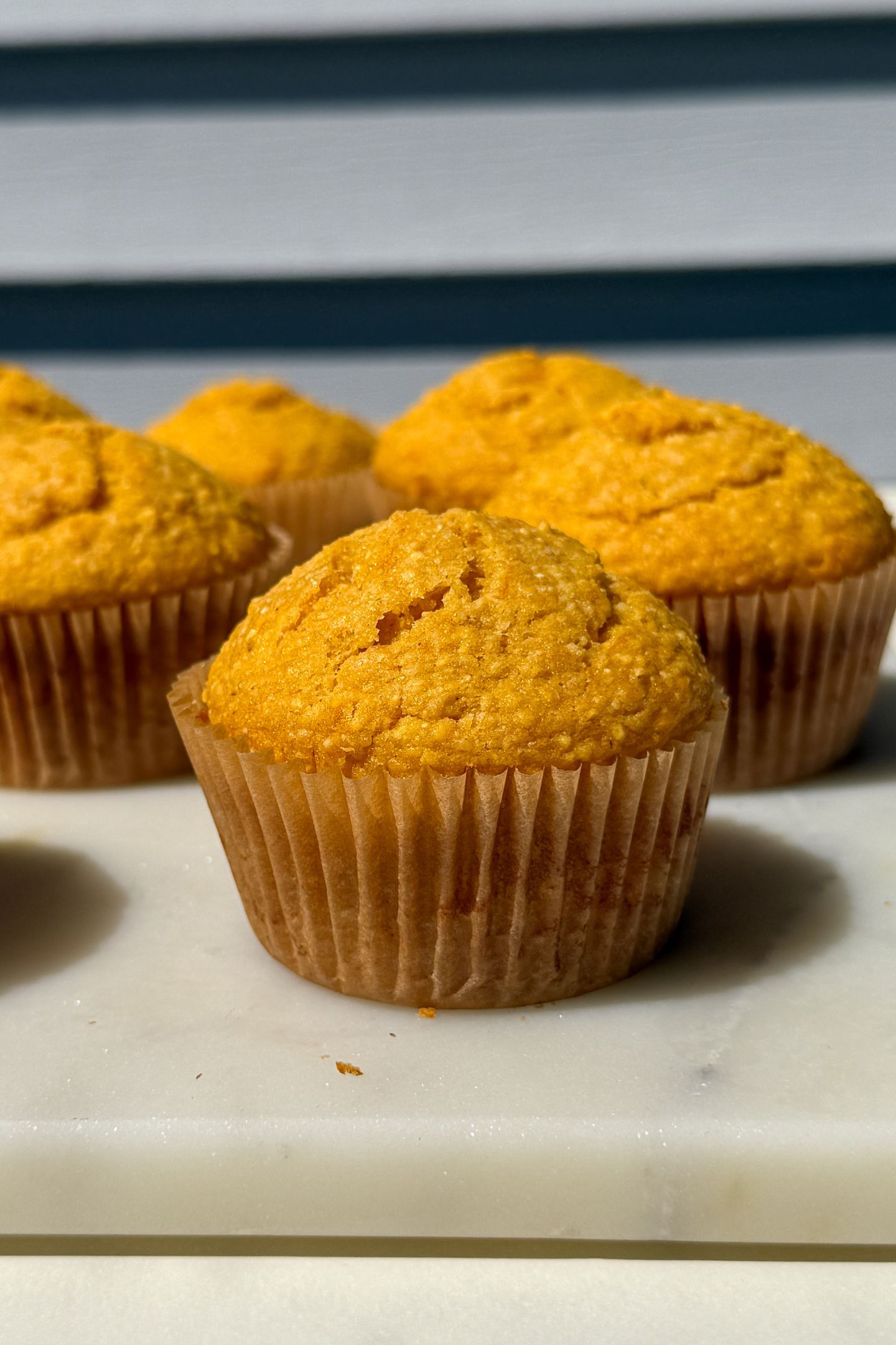 Cornbread muffins on a platter in their muffin wrappers.