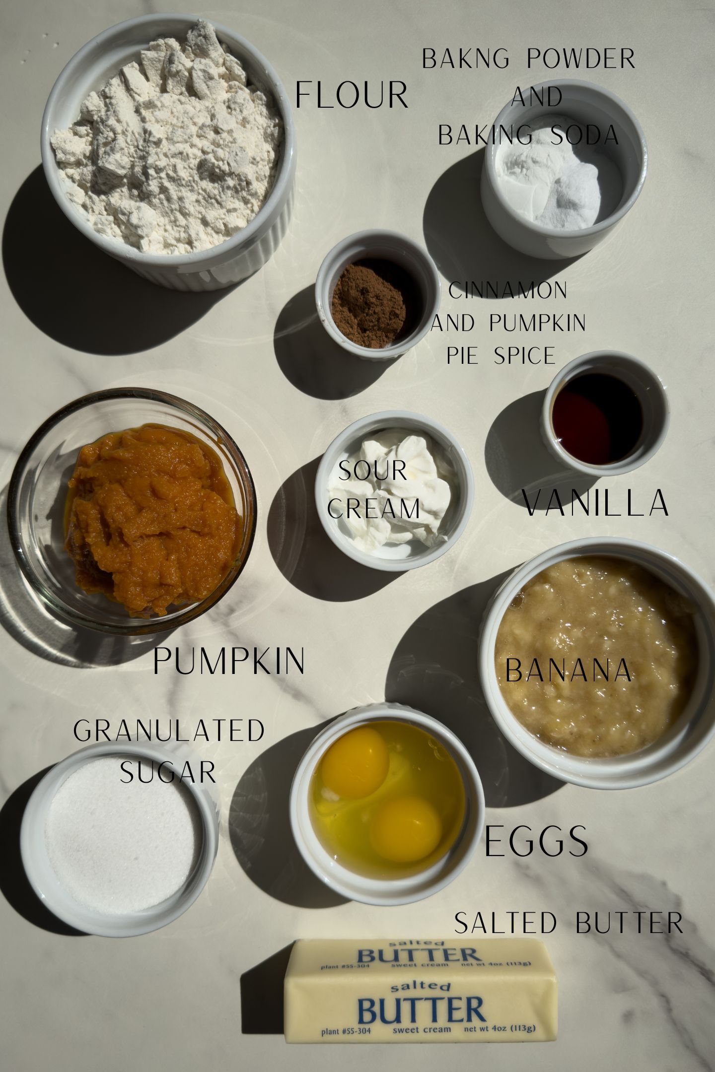 Ingredients measured out in bowls to make the banana bread pumpkin muffins.