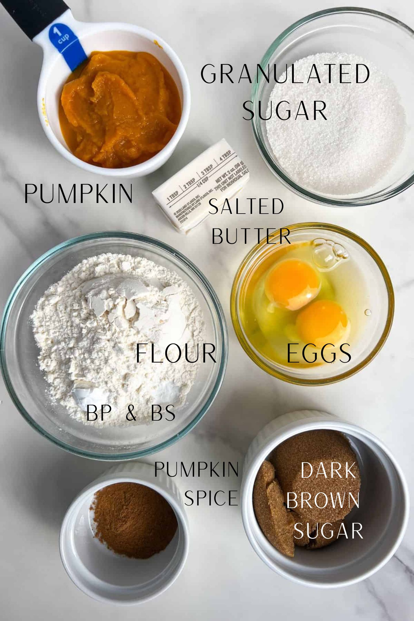 Ingredients measured out to make pumpkin donuts with labels.