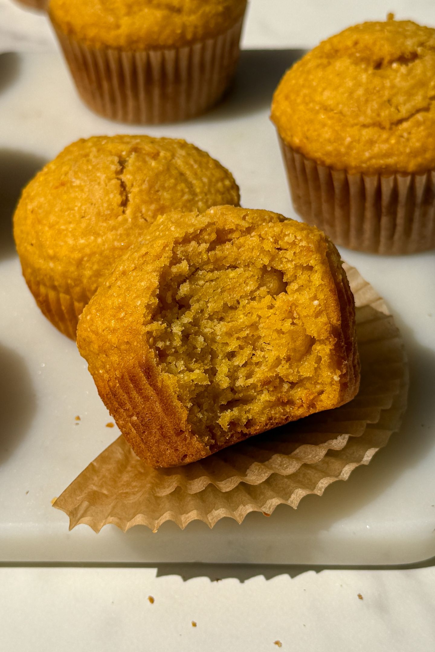 Corn Muffins on a plate with a bite taken out of one.