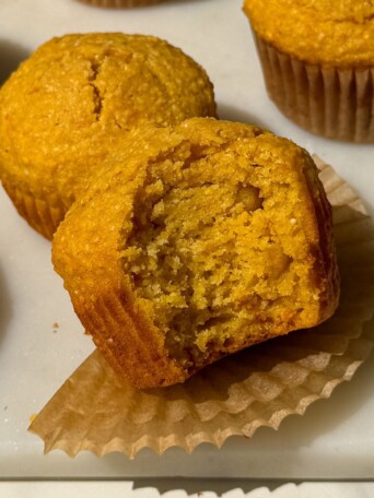 Corn and sweet potato muffin with a bite taken out of it.