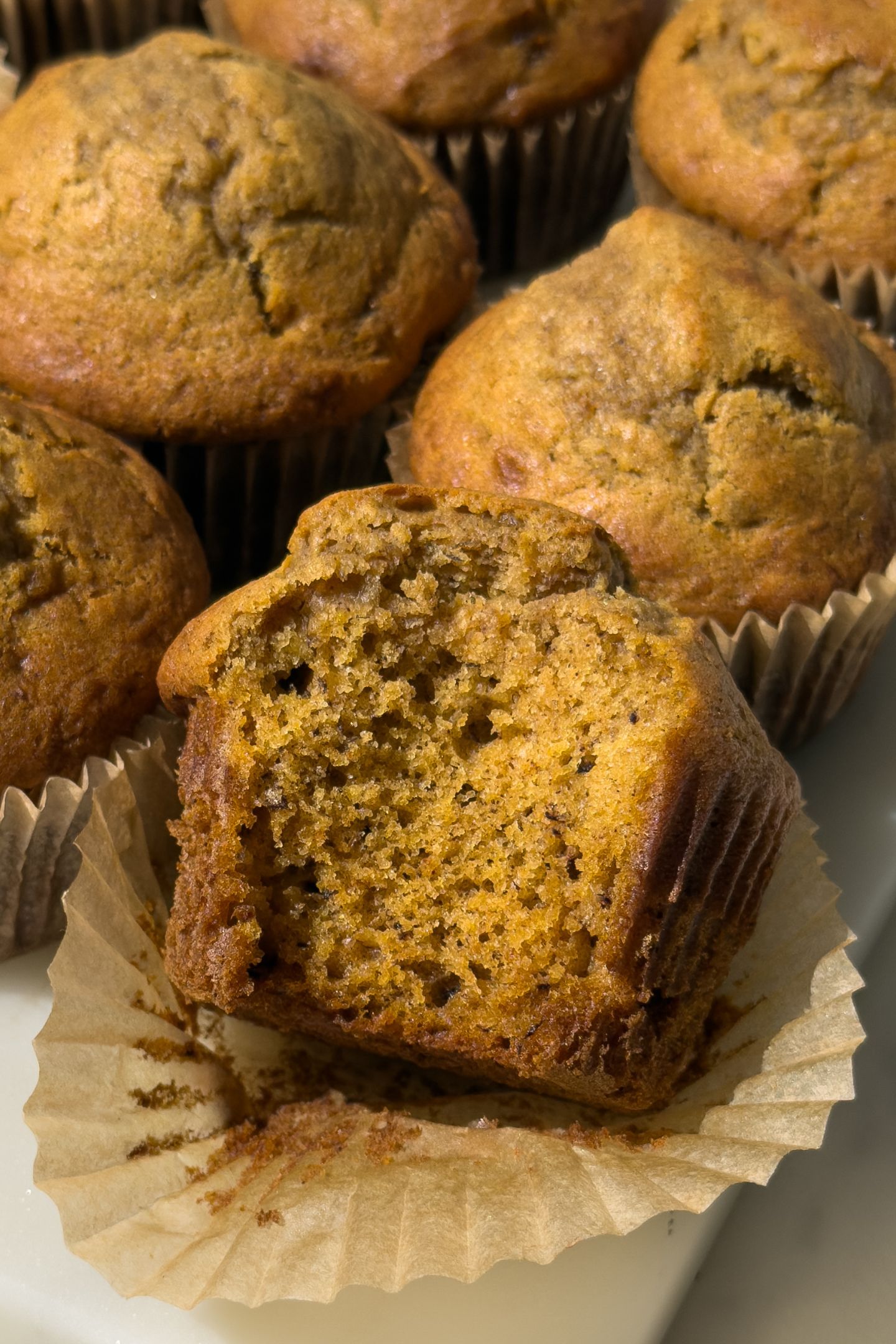 Pumpkin banana bread muffin with a bite taken out of it.