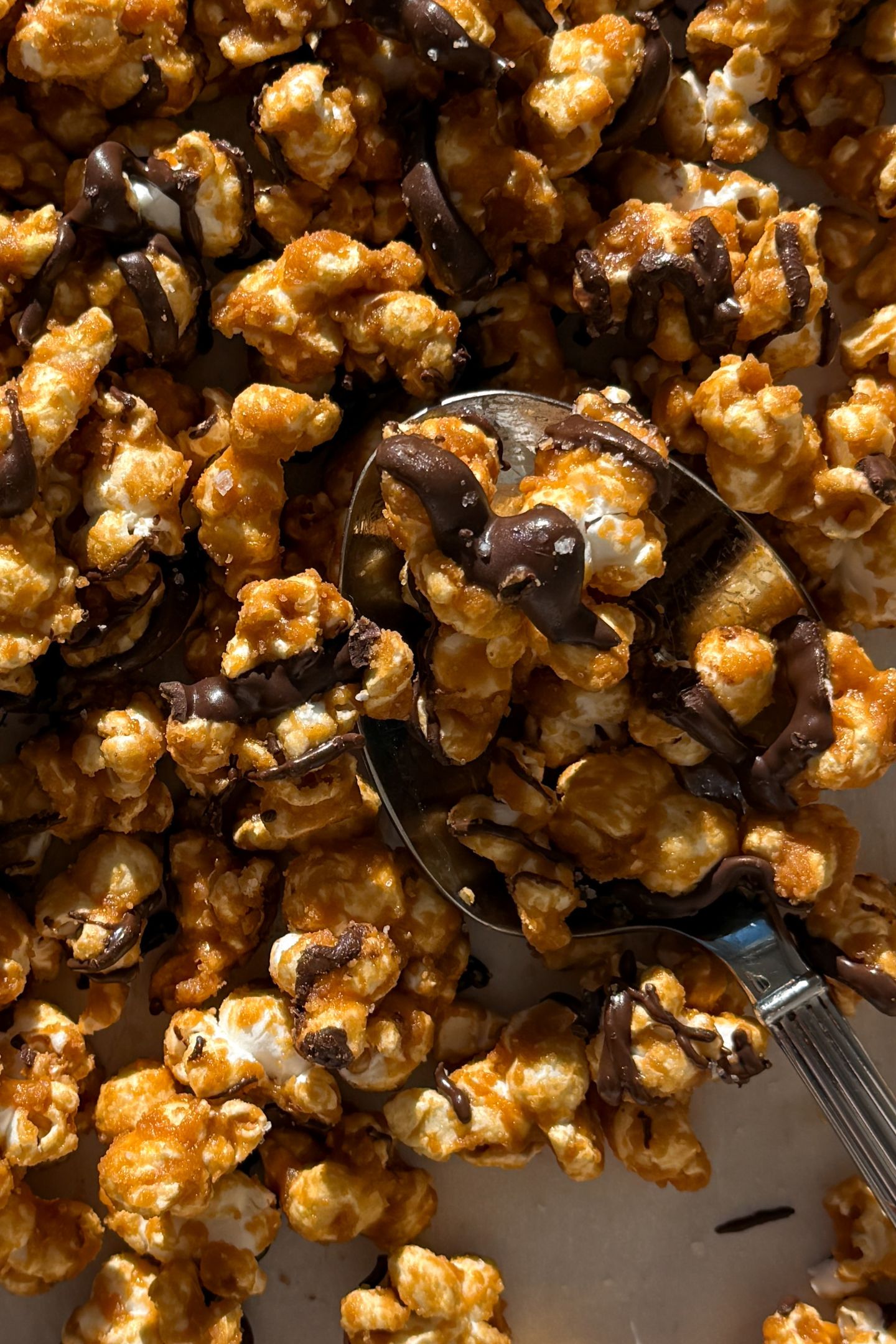 Scooping chocolate caramel popcorn.