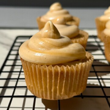 Side view of a cupcake topped with salted caramel frosting.