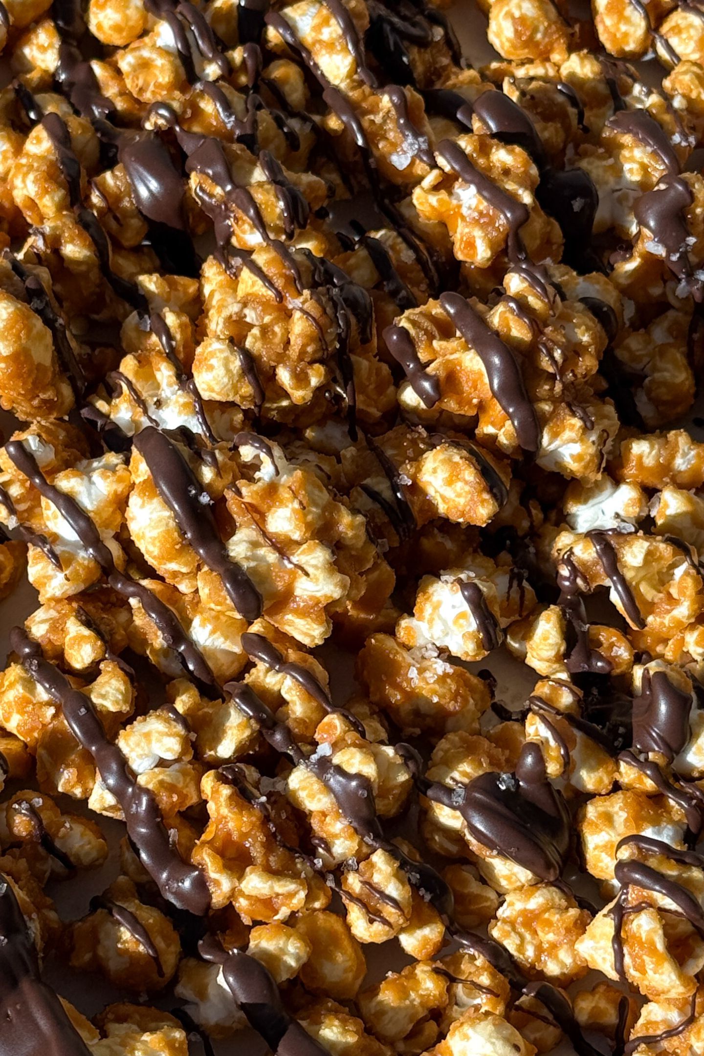 Drizzling chocolate over the caramel popcorn.