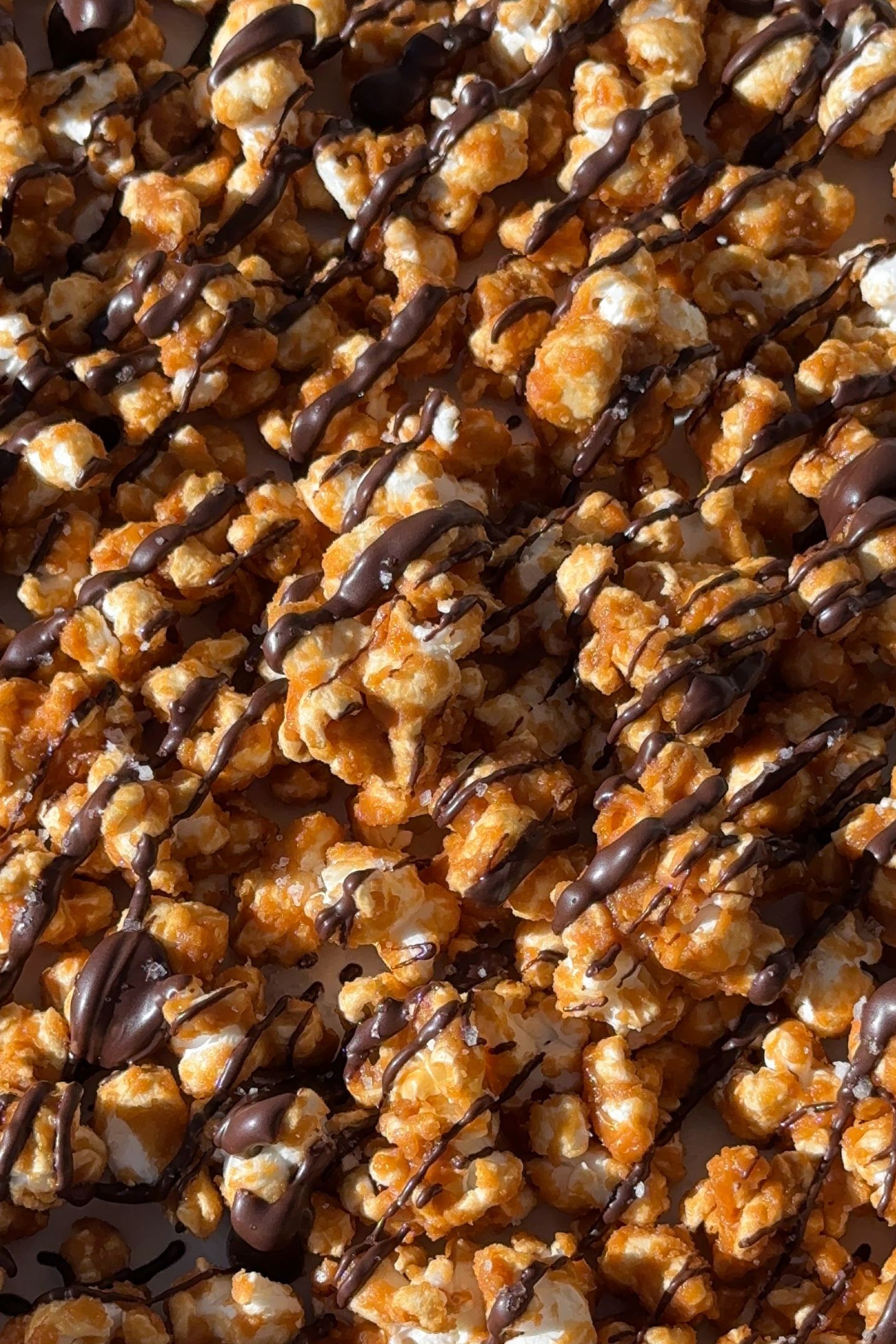 Drizzling chocolate over the caramel popcorn.