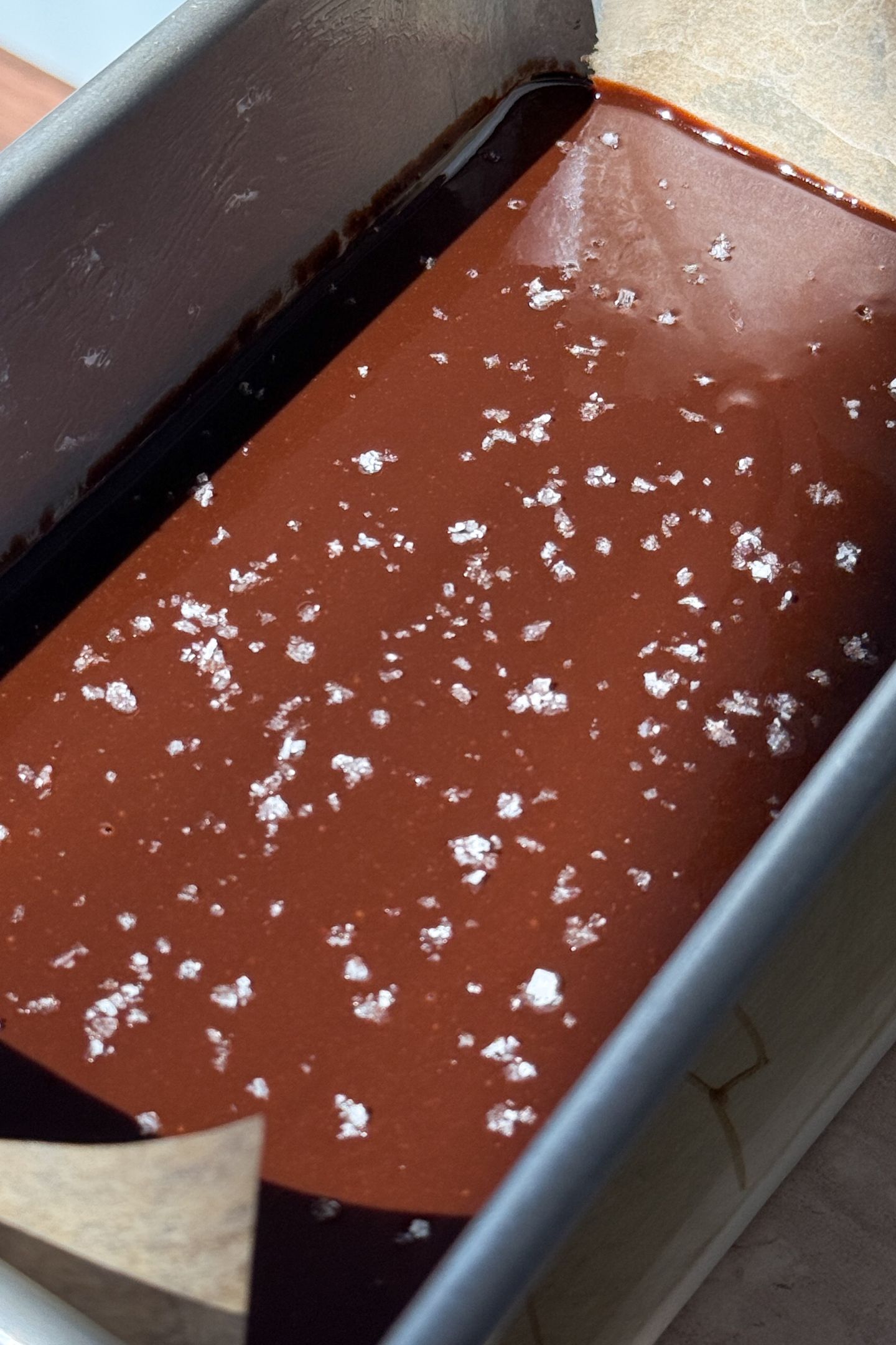 Melted fudge in a loaf pan topped with sea salt flakes.