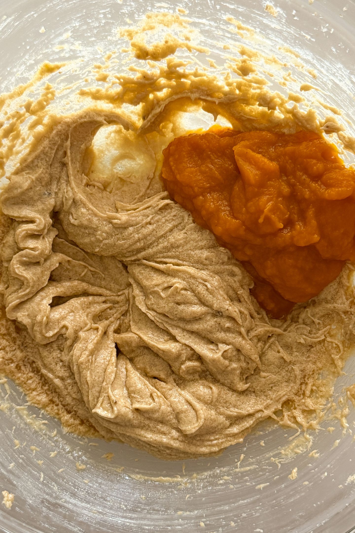 Combining the wet ingredients and pumpkin puree in a bowl.