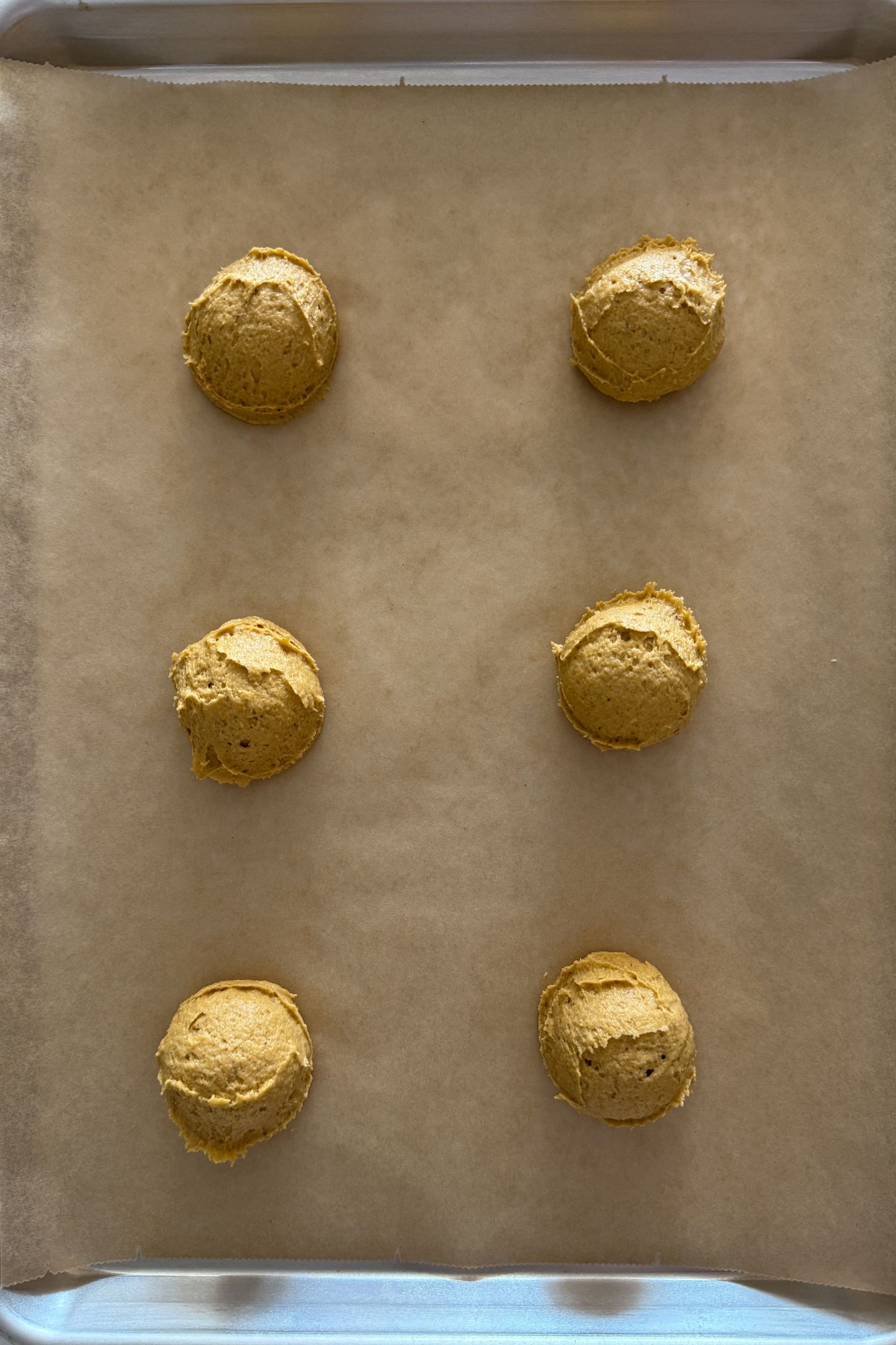 Cookie dough on baking sheet lined with parchment paper.