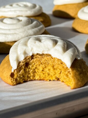 Frosted Pumpkin Cookie with a bite taken out of it.