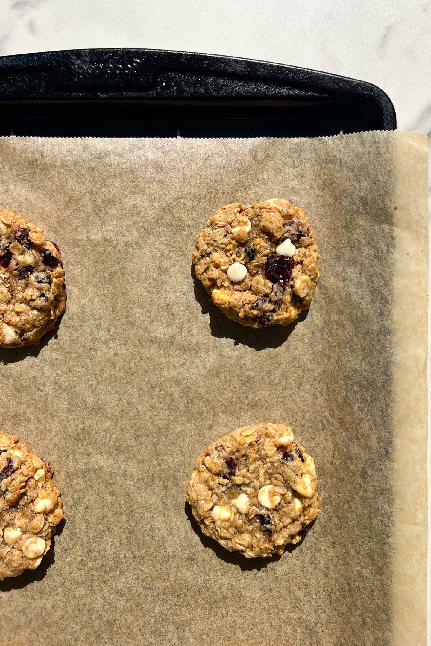 White Chocolate Dried Cranberry Oatmeal Cookies on a baking sheet lined with parchment paper.