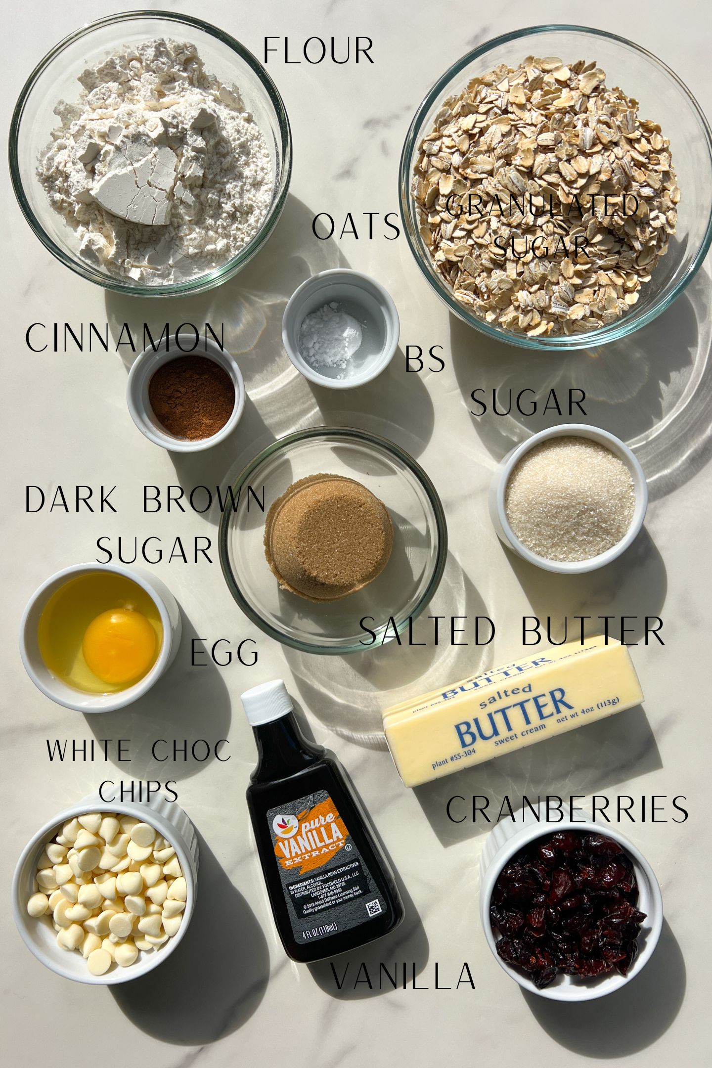 Labeled photo of the ingredients to make the white chocolate and dried cranberry cookies.