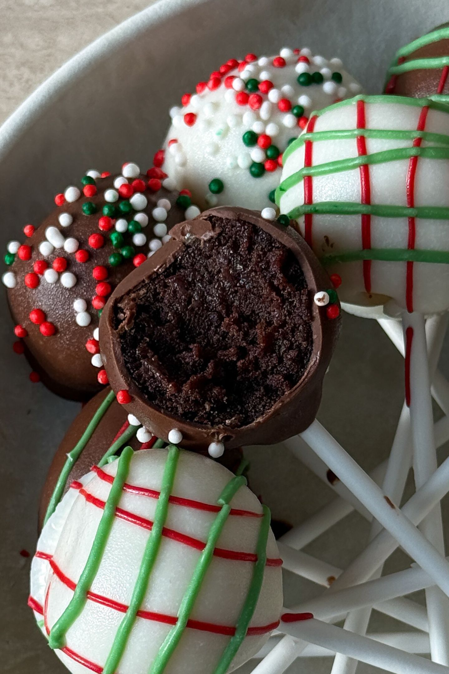 Christmas Cake Pops on a platter with a bite taken out of one.