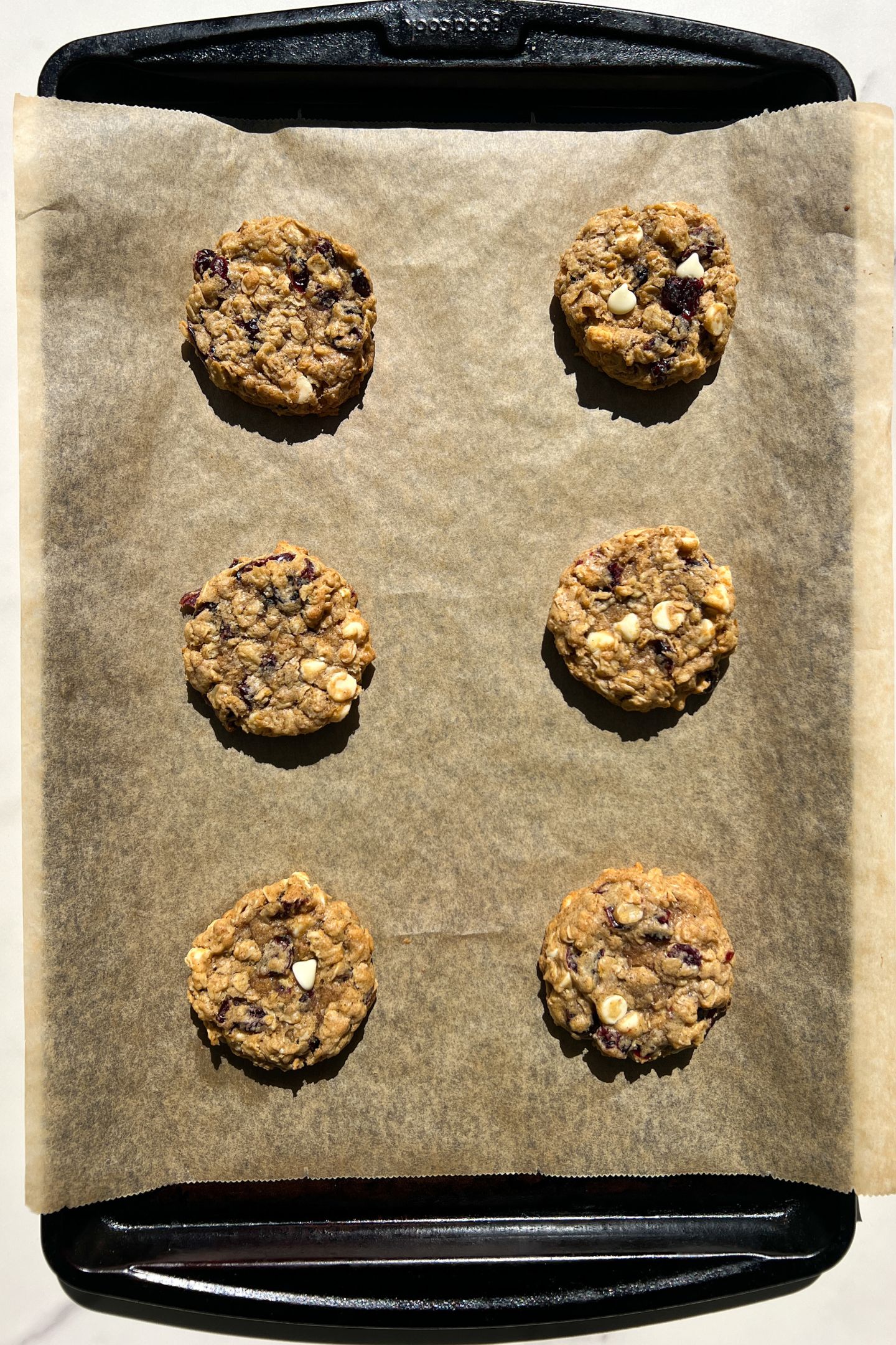 White Chocolate Dried Cranberry Oatmeal Cookies on a baking sheet lined with parchment paper.