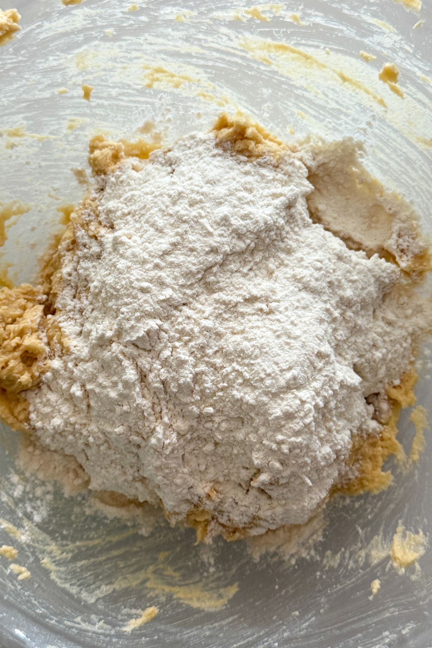 Adding dry ingredients to the wet in a bowl.