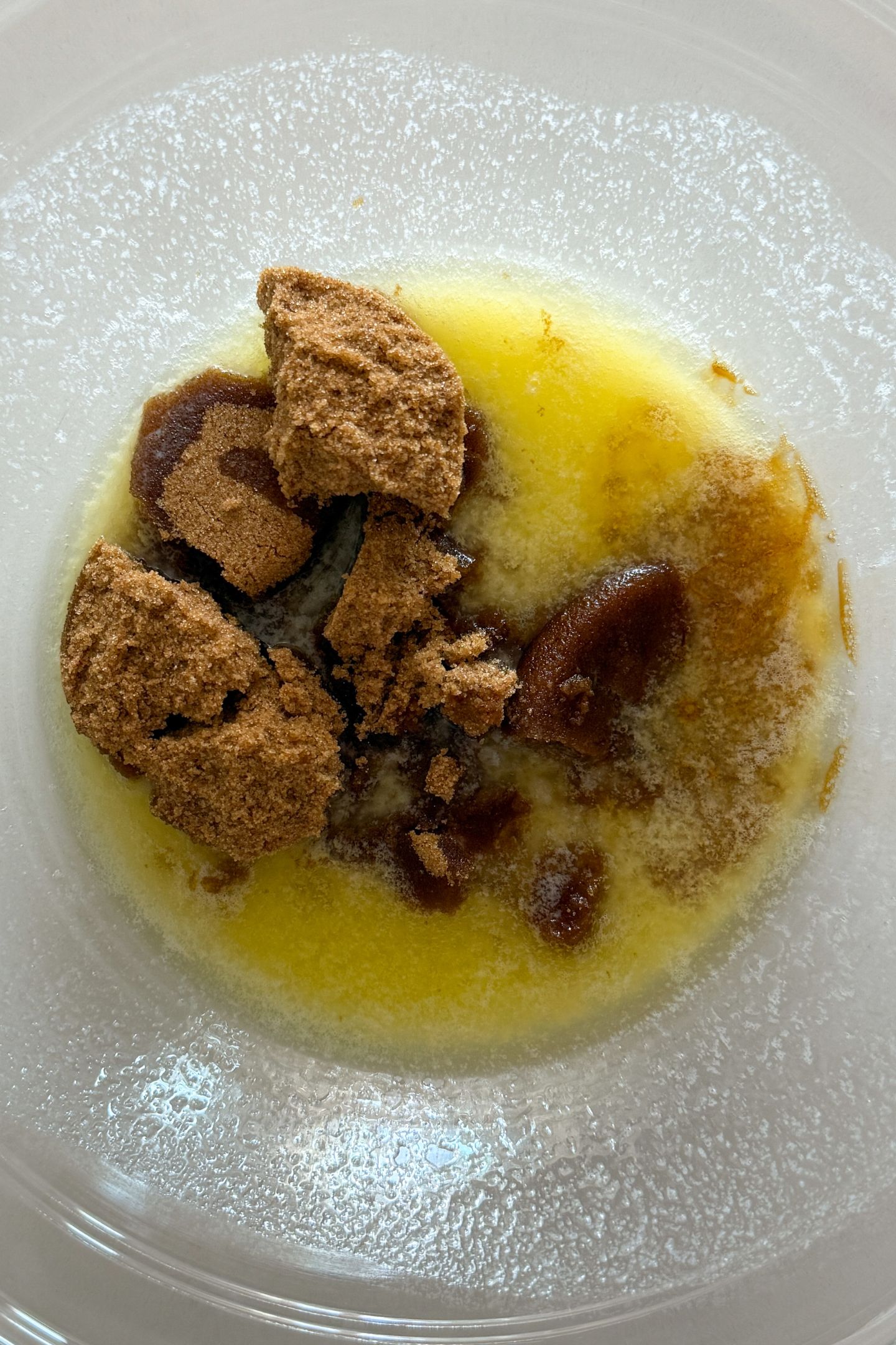 Salted butter melted in a bowl with dark brown sugar.