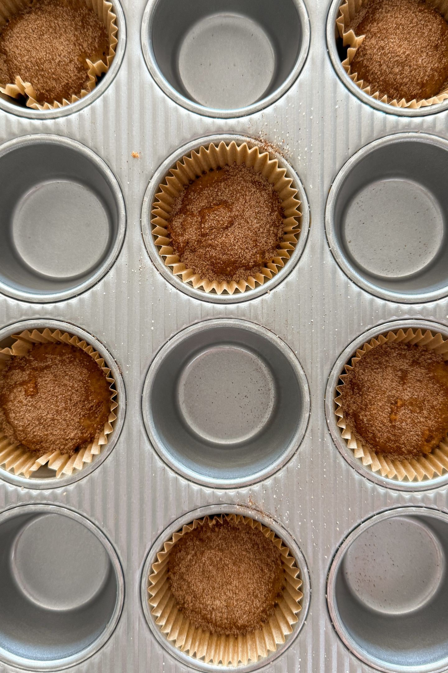 Assembling the cinnamon streusel muffins in the muffin tin.