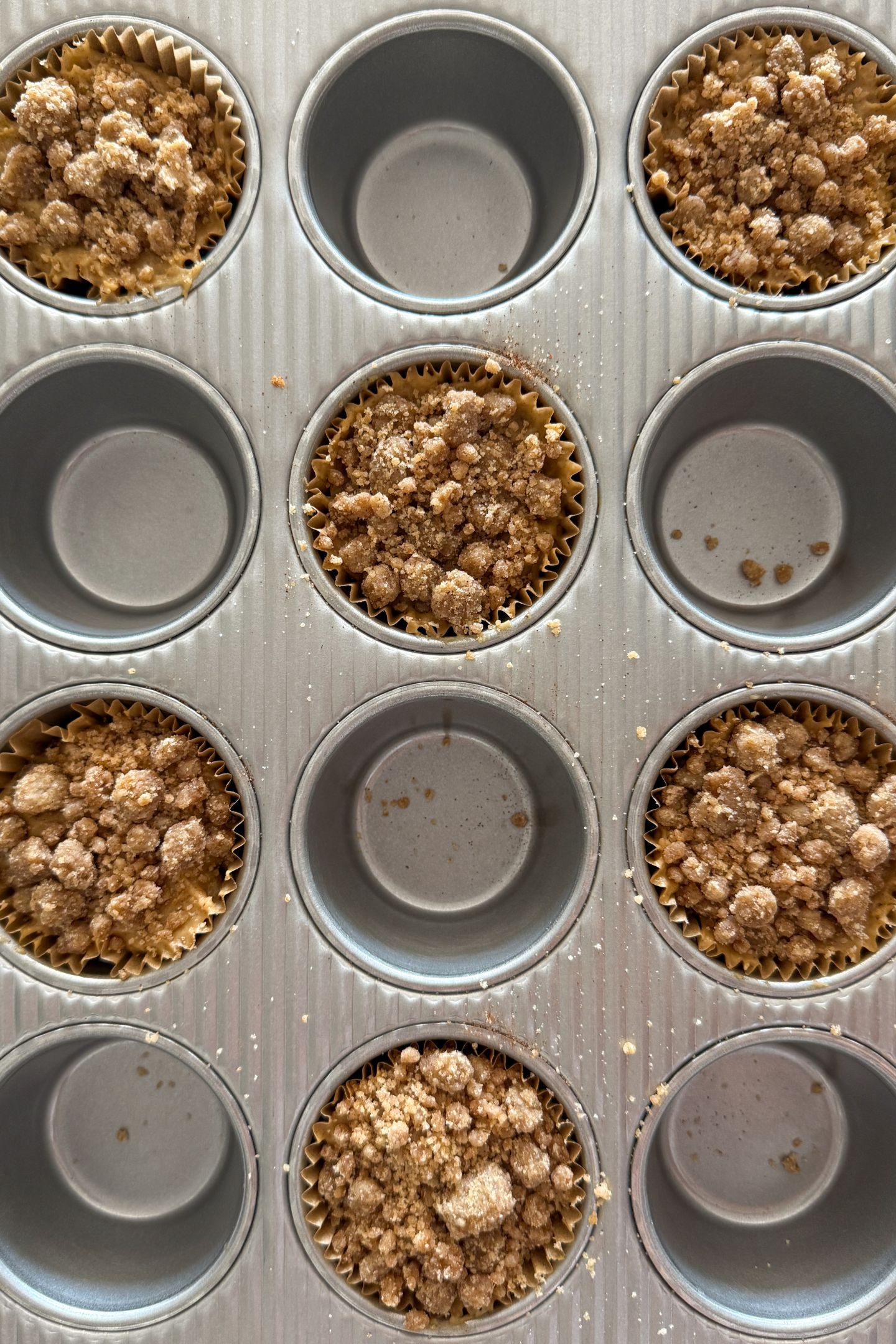 Assembling the cinnamon streusel muffins in the muffin tin.