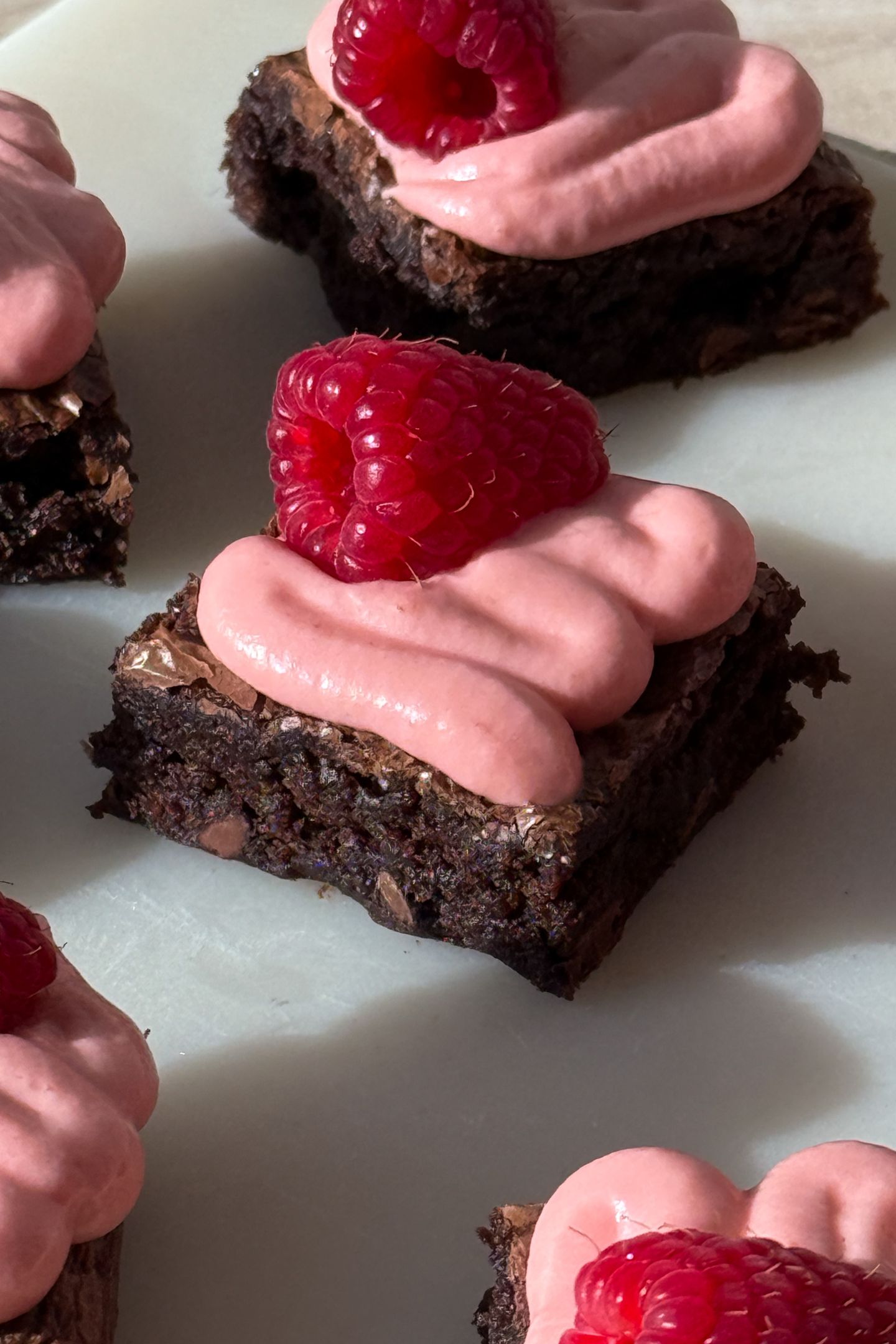 A fudge brownie topped with a swirl of raspberry cream cheese frosting.