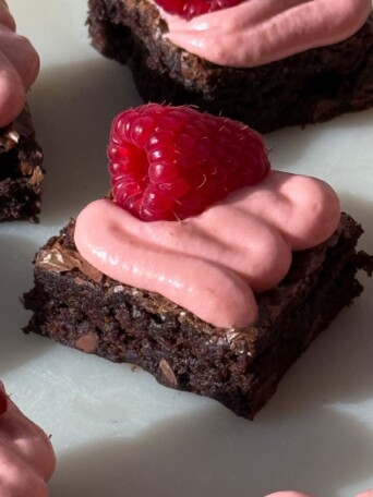 A fudge brownie topped with a swirl of raspberry cream cheese frosting.