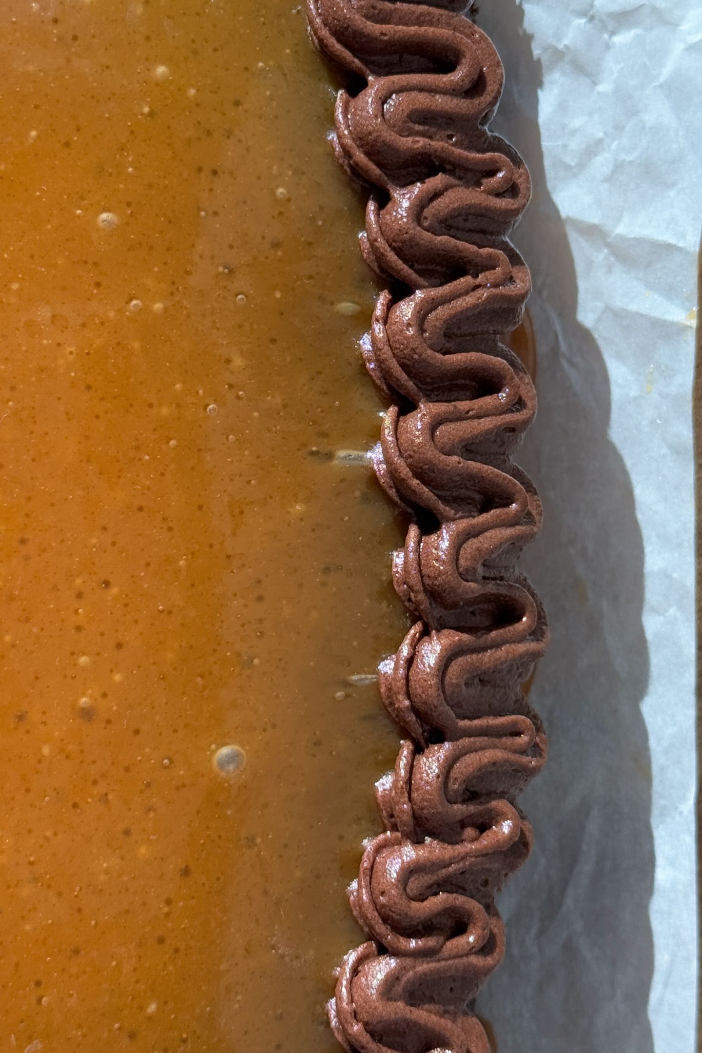 Piping the chocolate frosting on the cake.