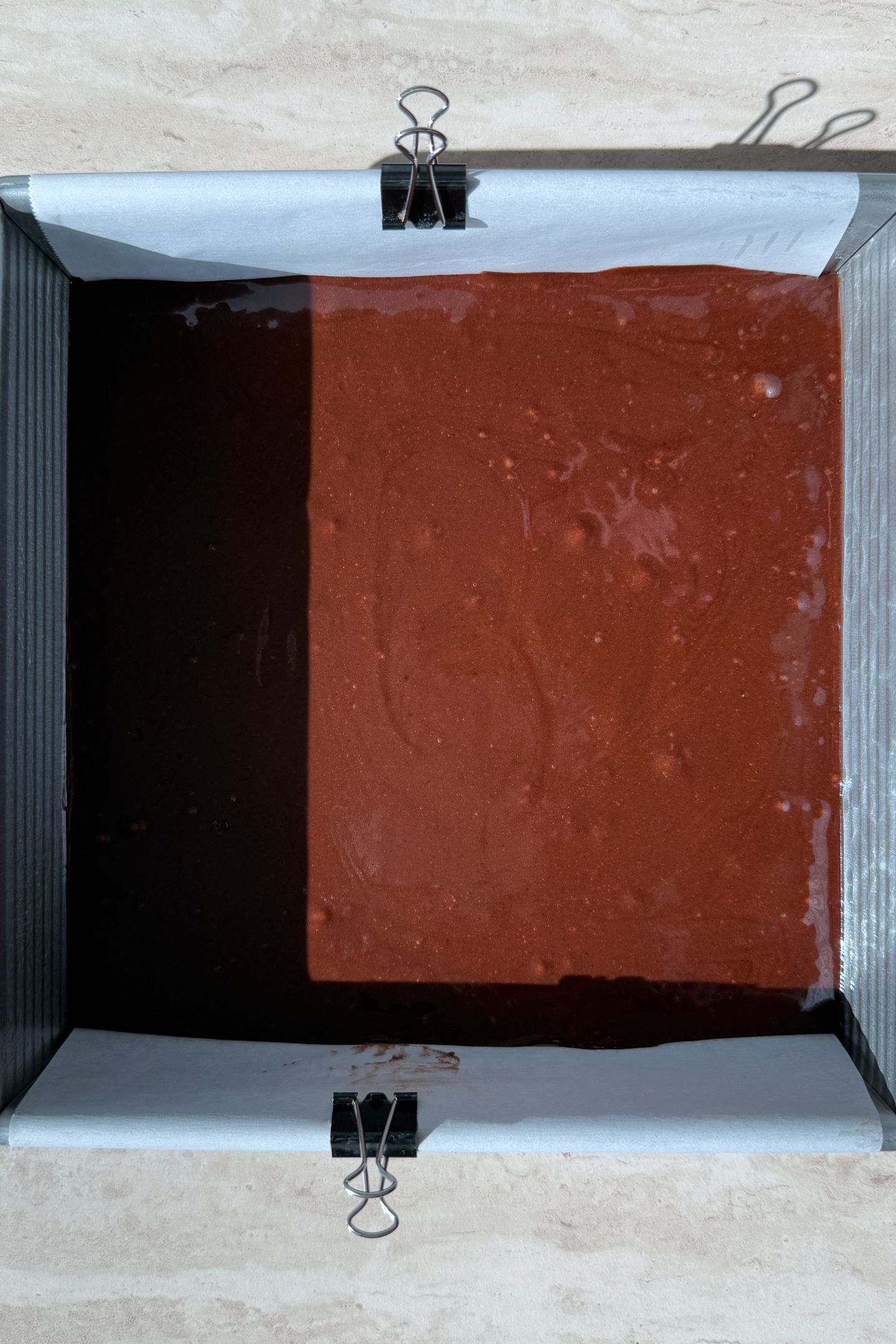 Chocolate cake batter in the prepared 8x8 square baking pan.