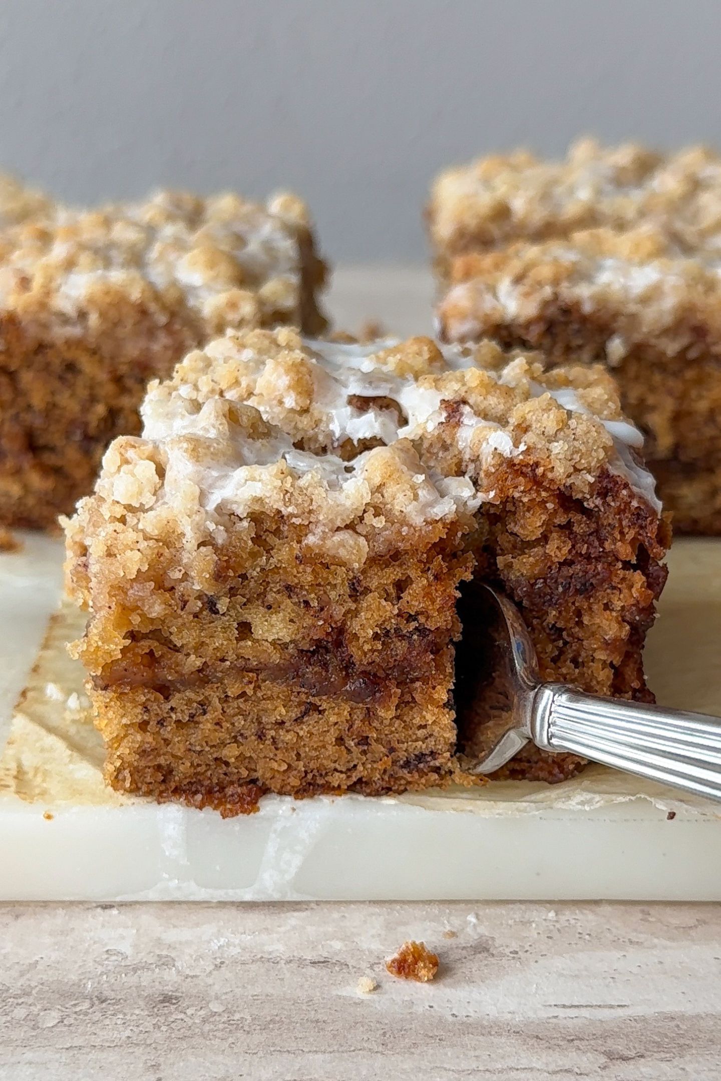 A fork cutting through a piece of banana bread coffee cake.