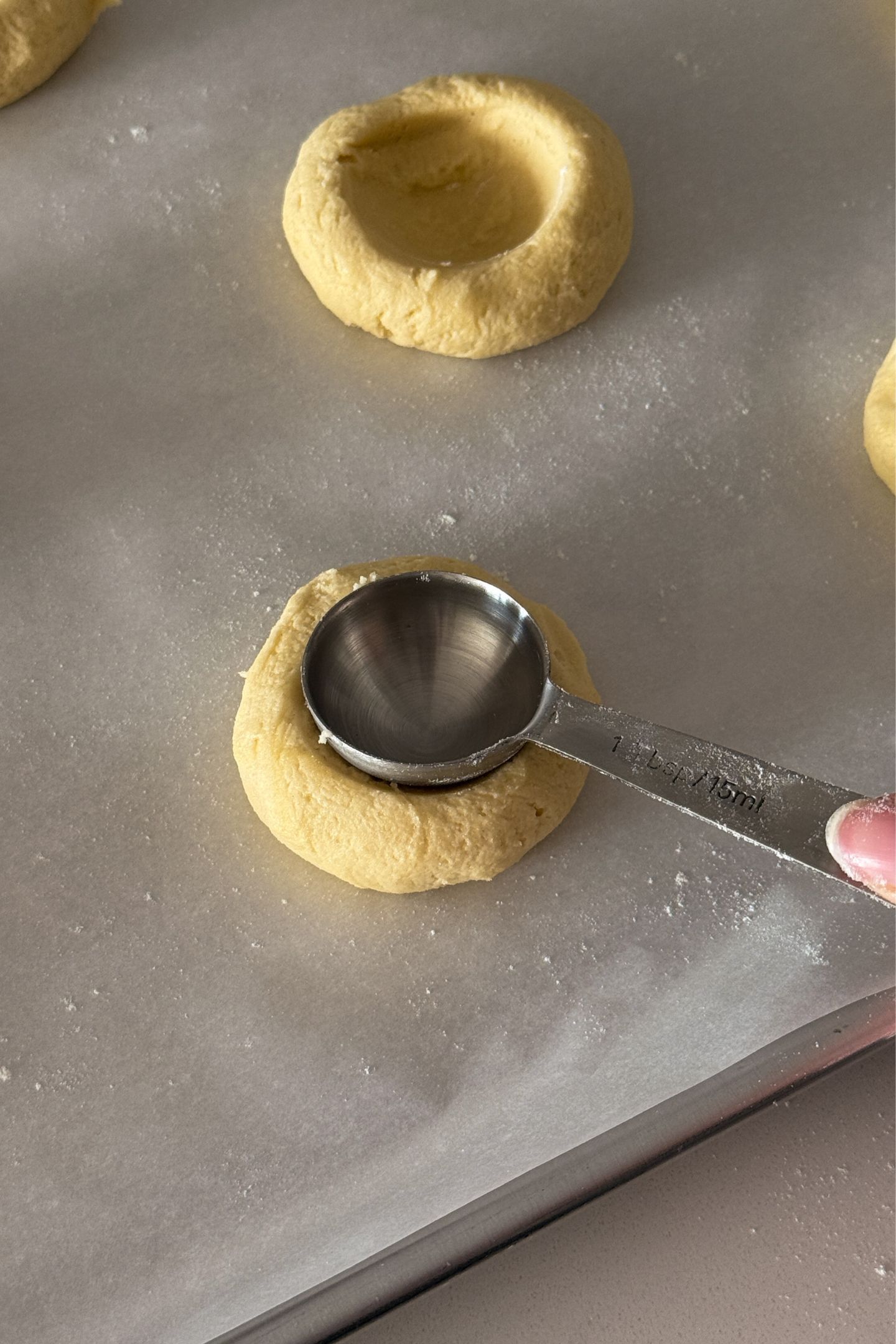 Creating divots in the cookie dough balls.