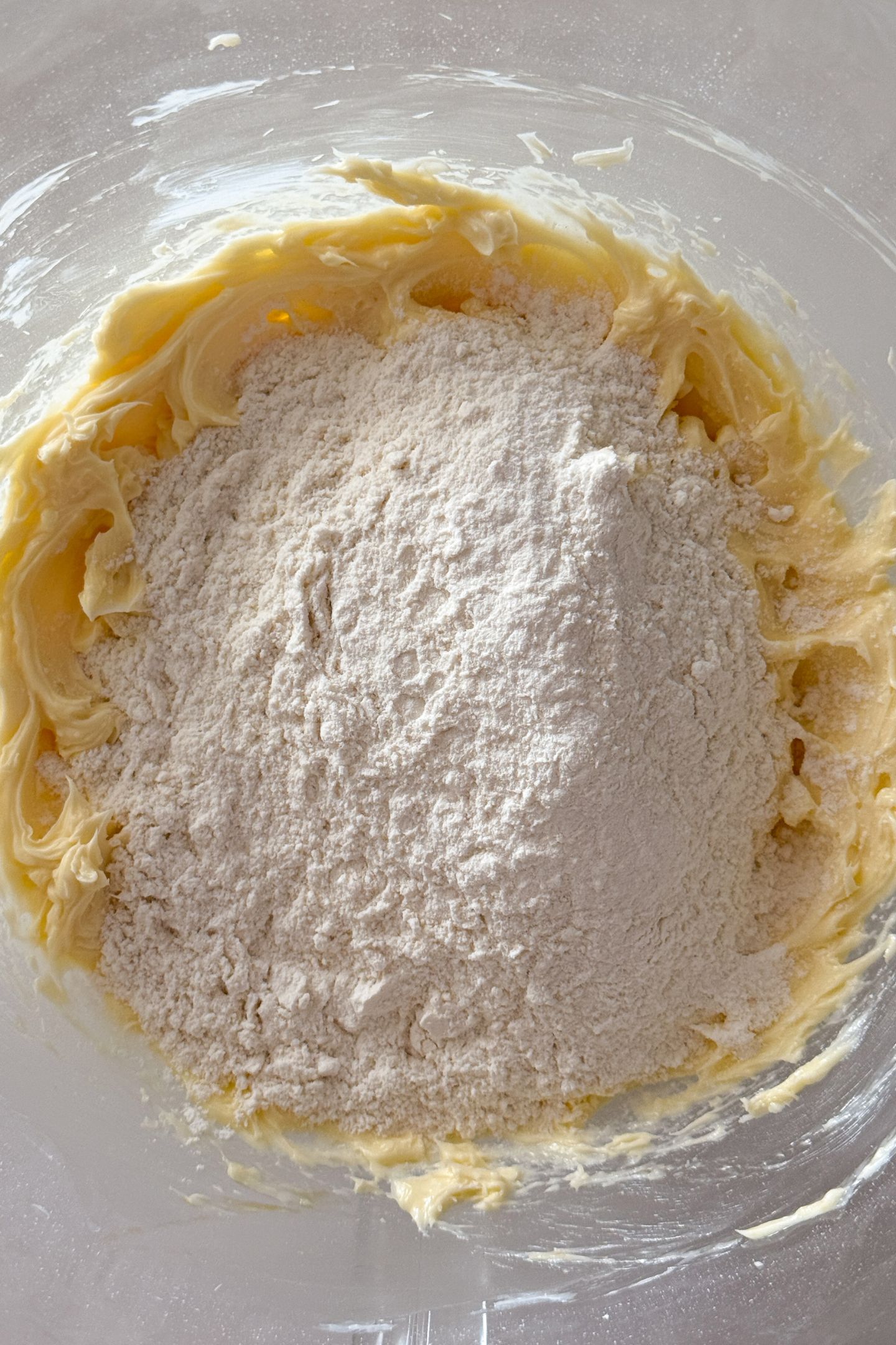 Adding flour to the cookie dough batter.