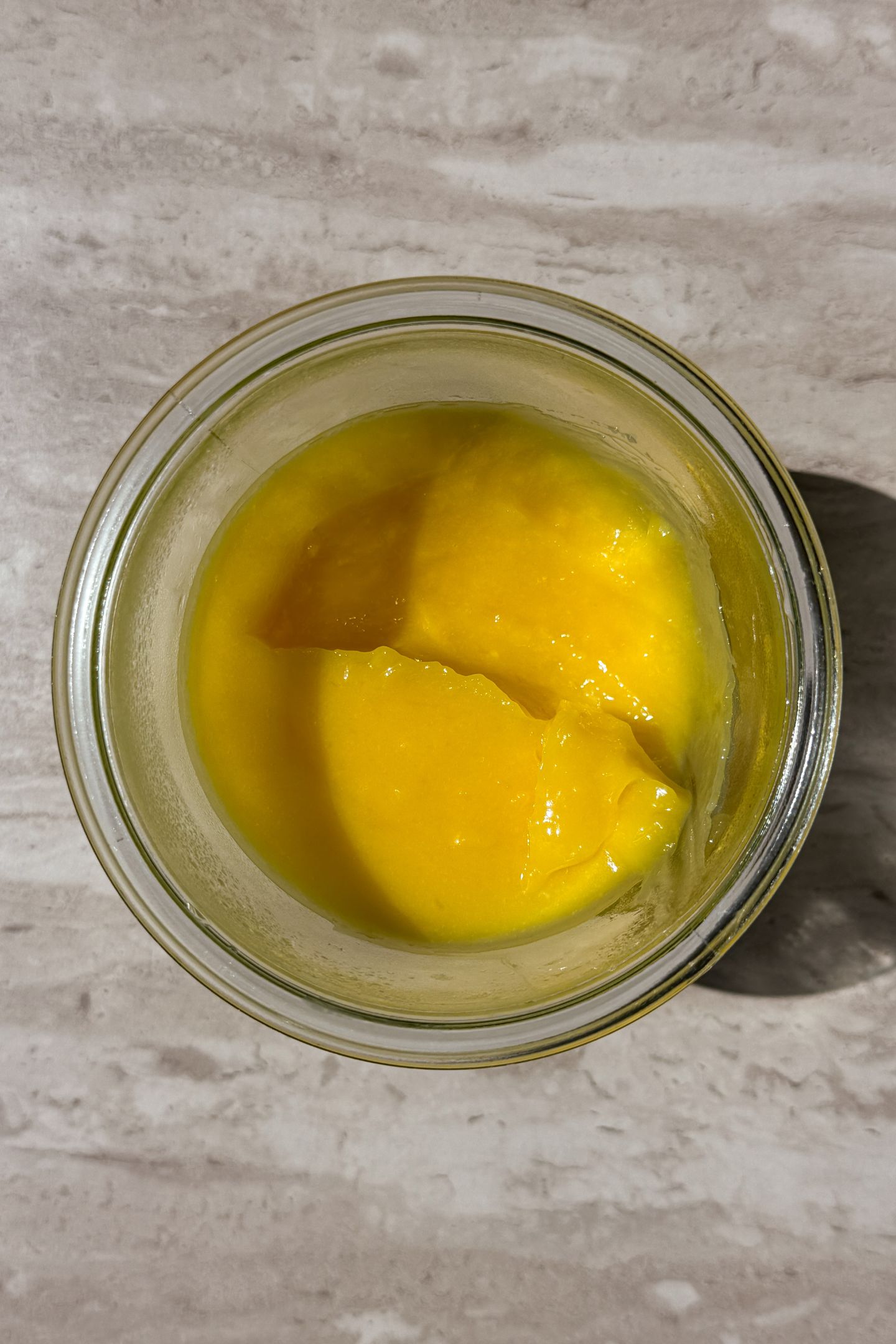 Scooping lemon curd out of a mason jar.