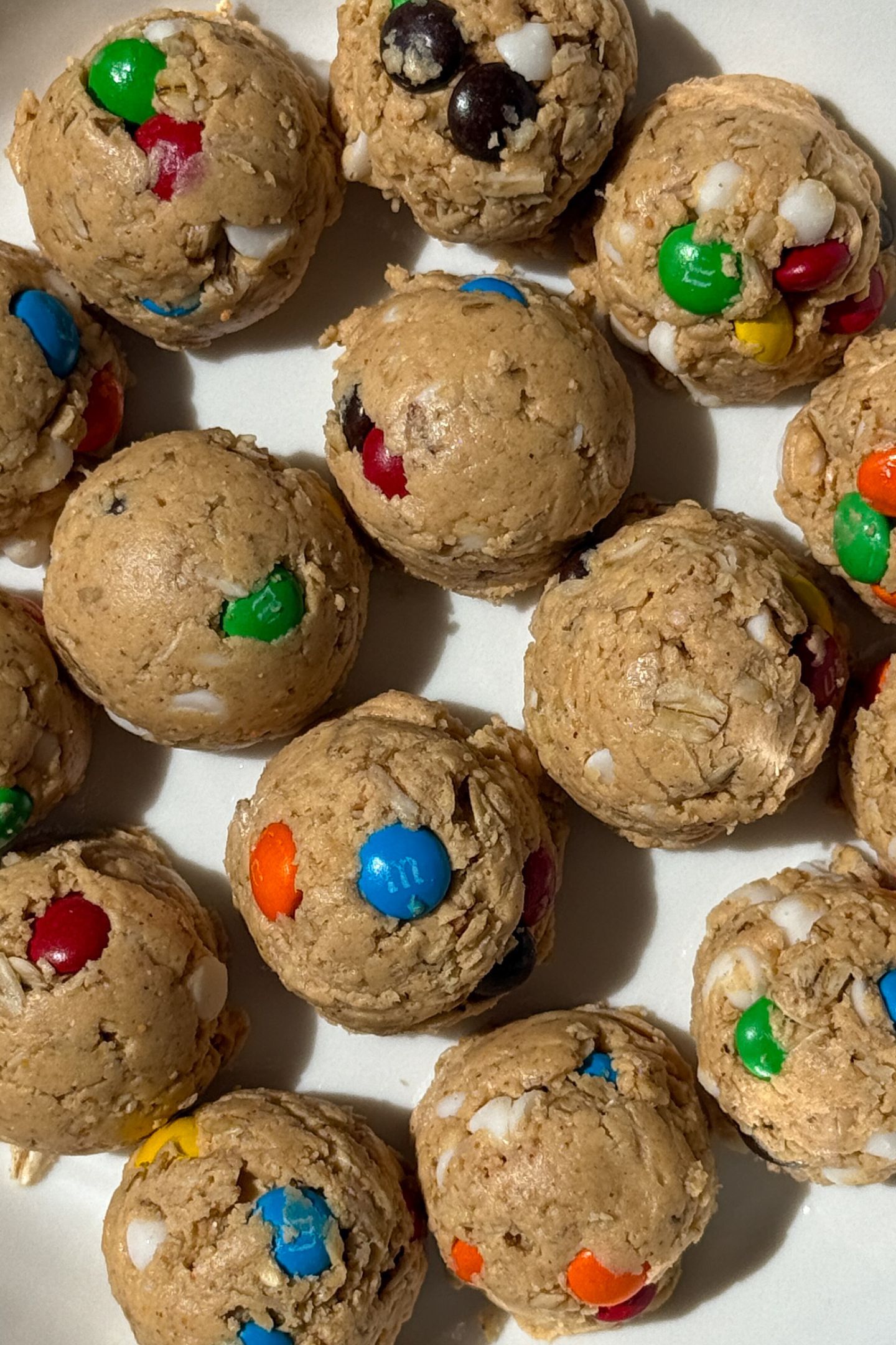 Perfectly portioned monster cookie protein balls on a plate.
