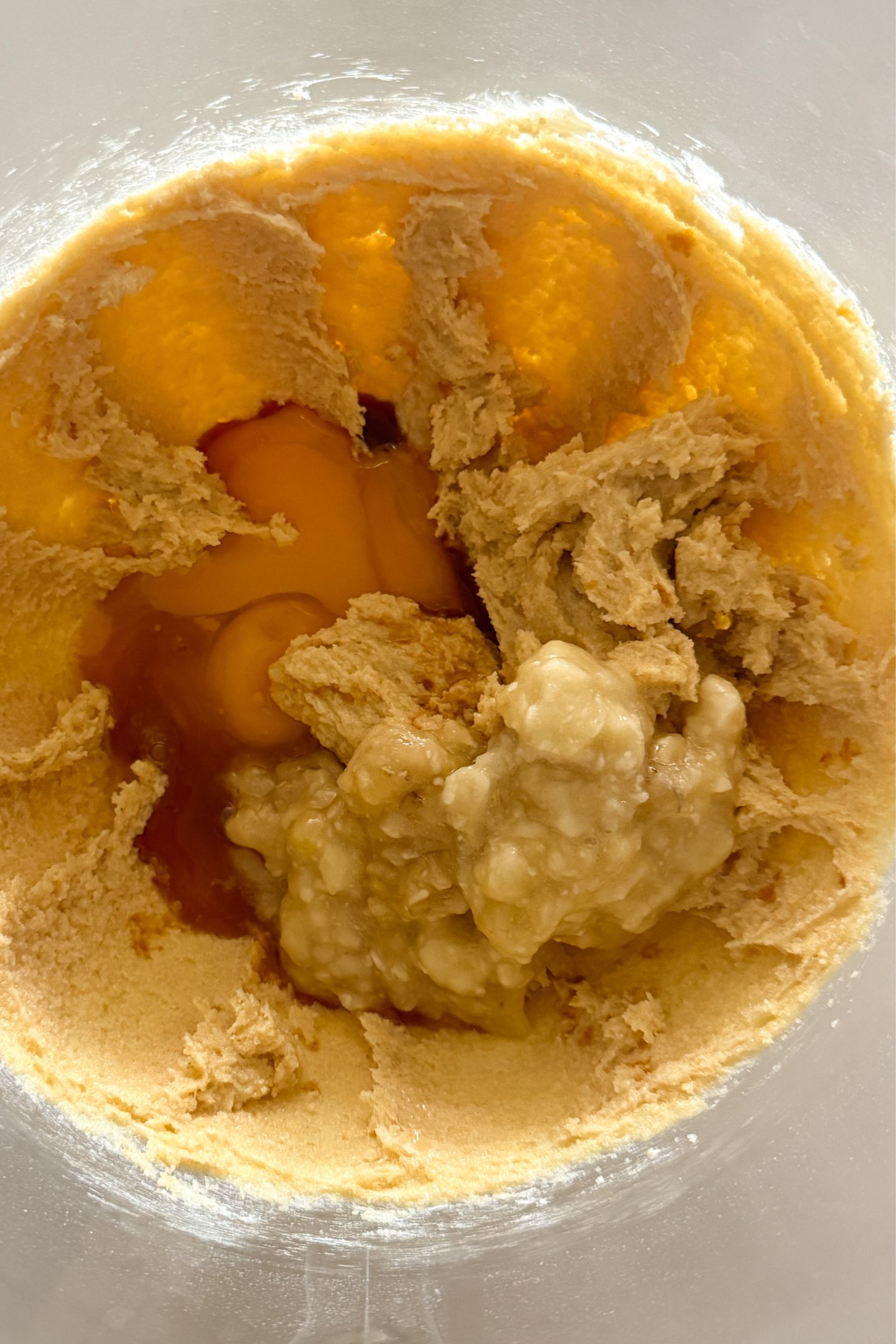 Adding eggs, vanilla and mashed banana to the wet ingredients.