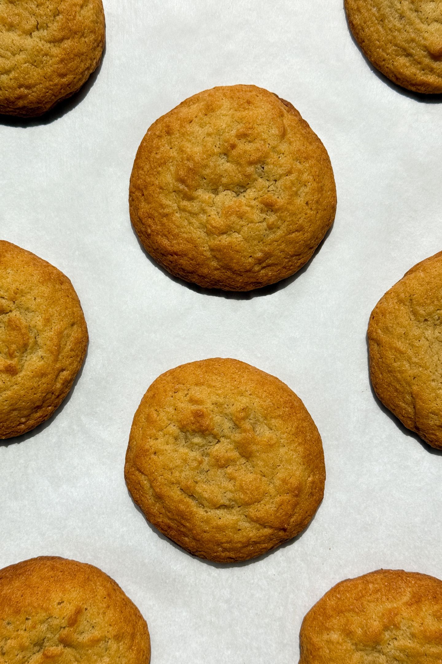 Baked banana pudding cookies on parchment paper.