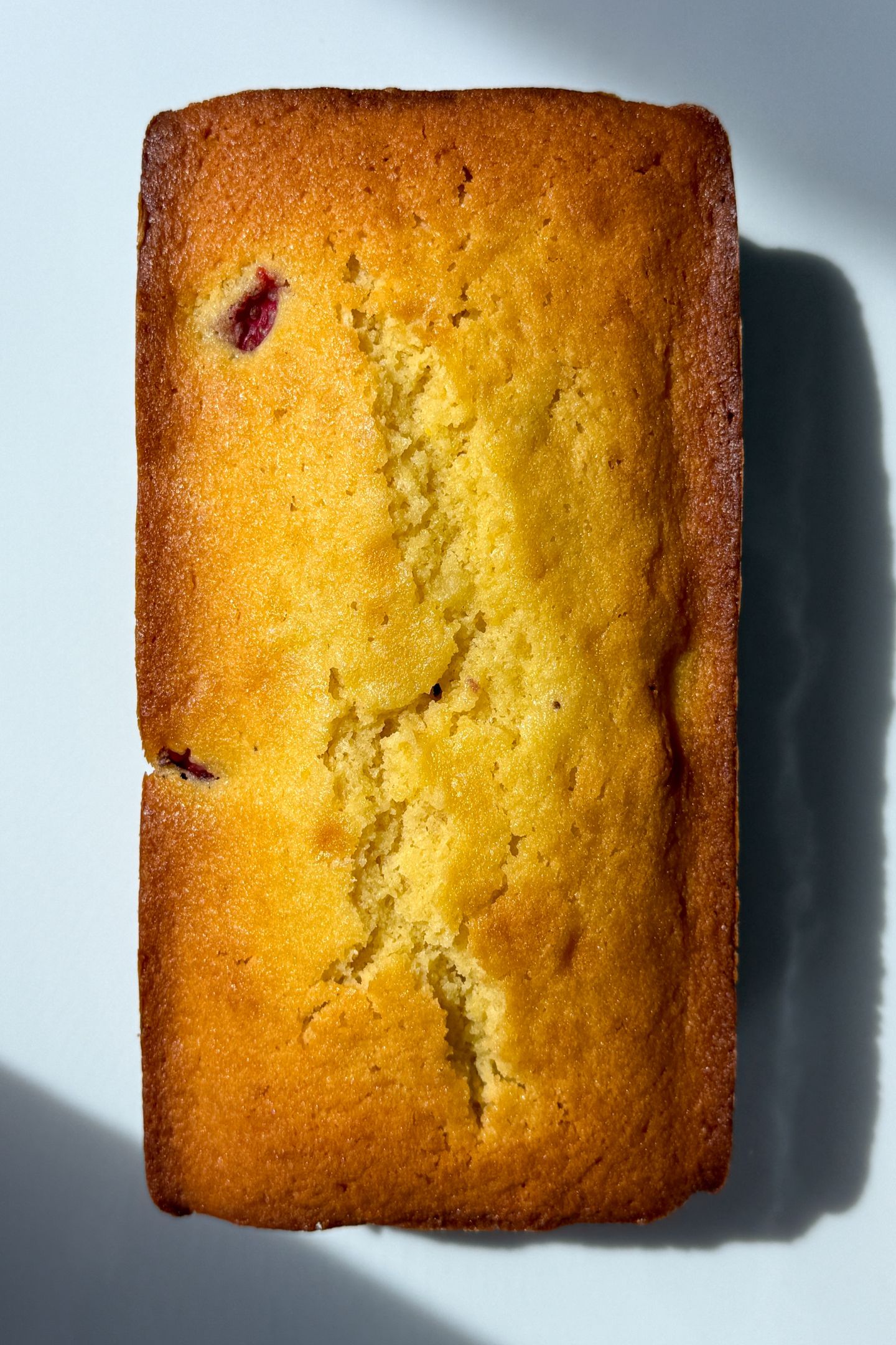 Baked Strawberry Lemon Pound Cake cooling on a platter.