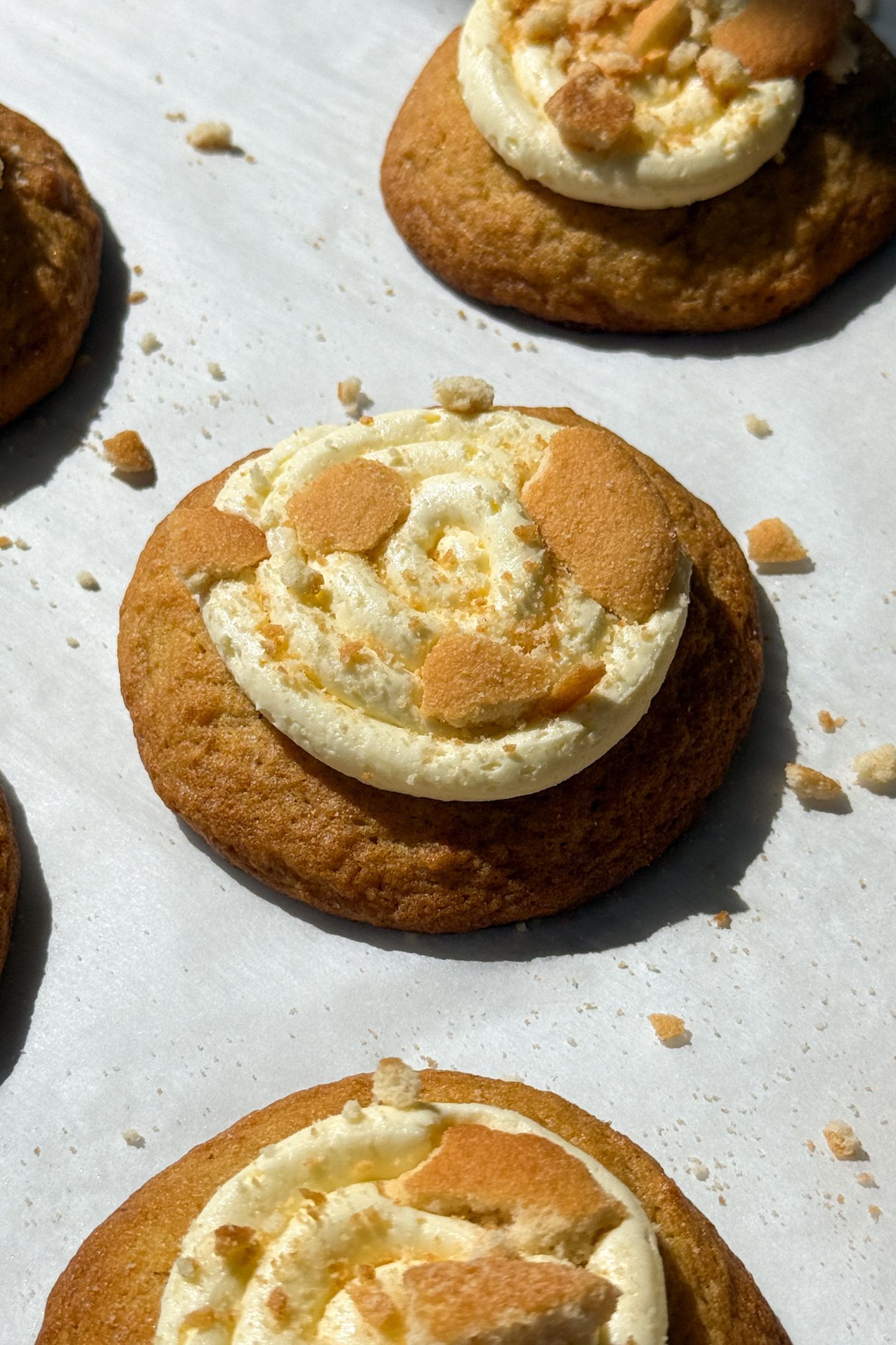 Banana pudding cookie topped with frosted and crushed cookies.