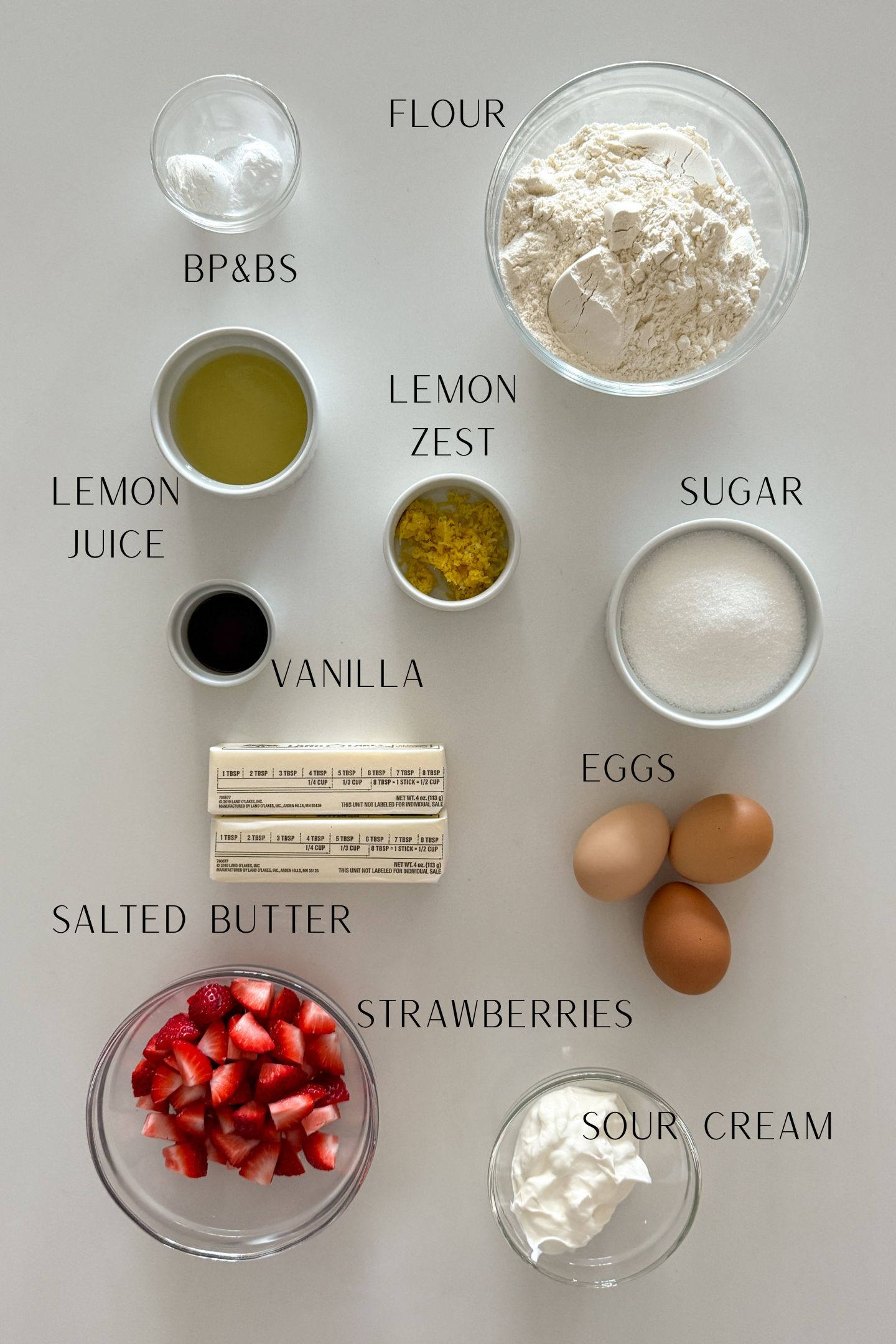Ingredients measured out in bowls to make the strawberry lemon pound cake with labels.