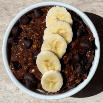 Chocolate Banana Overnight Oats prepared in a bowl with toppings added on.