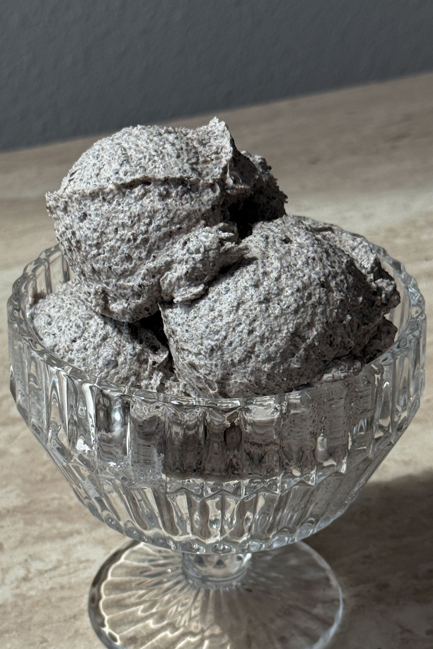 Scoops of oreo buttercream frosting in a glass serving bowl.