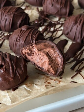 A chocolate cheesecake bite with a bite taken out of it to show the center and layers.
