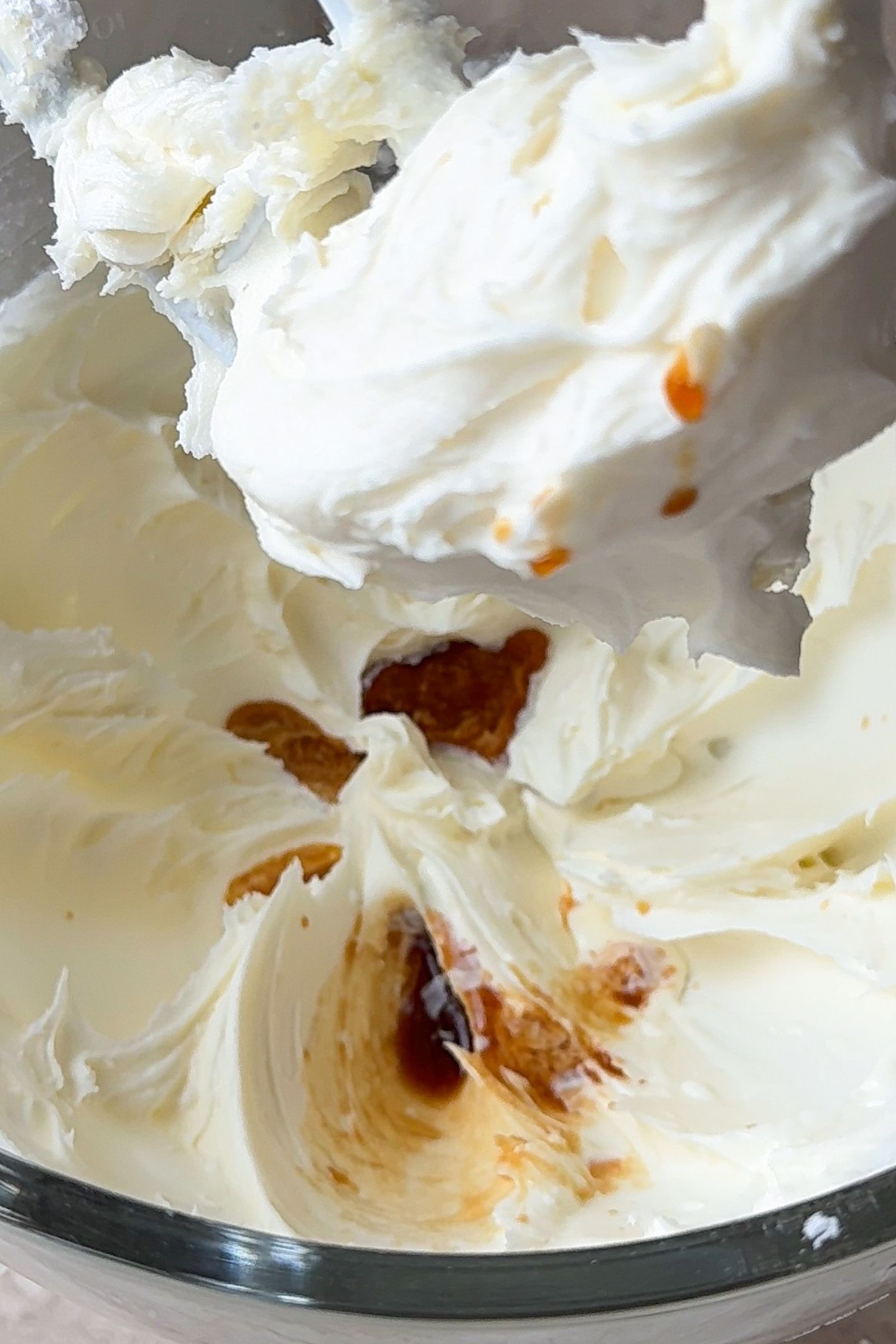 Adding the vanilla extract and heavy cream to the base of the oreo frosting in a stand mixer.